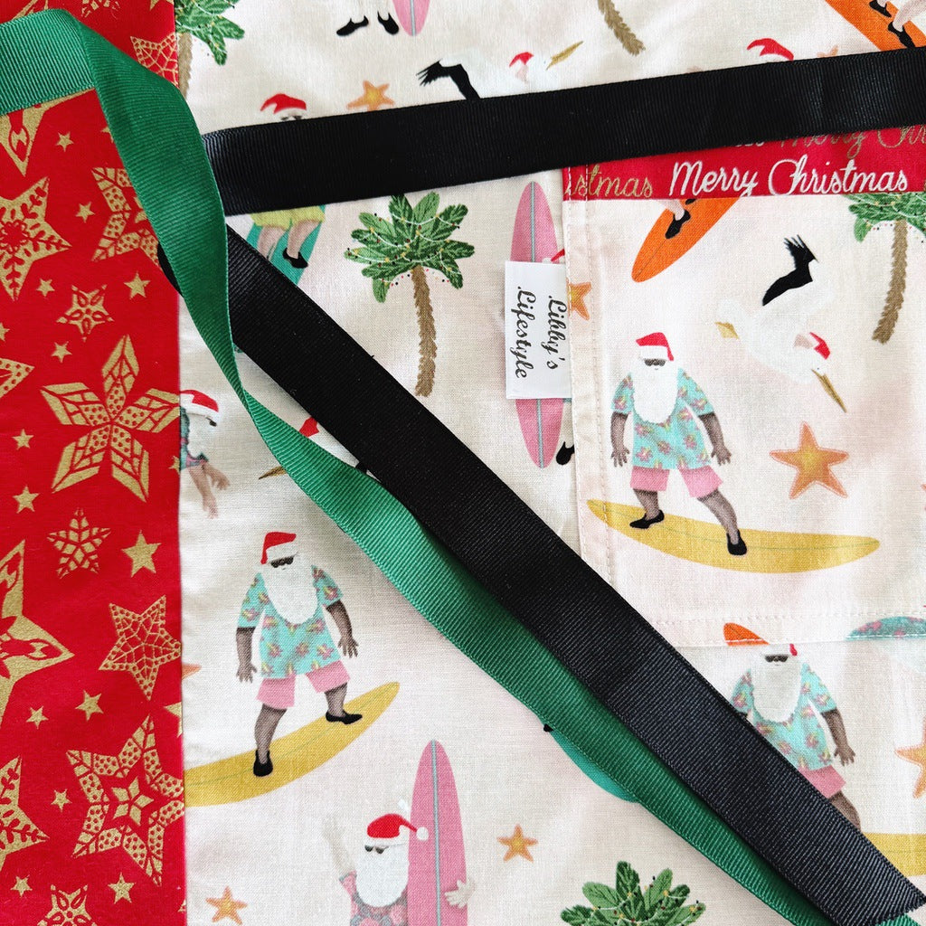 Surfing Santas. Ladies' Christmas tie back apron.