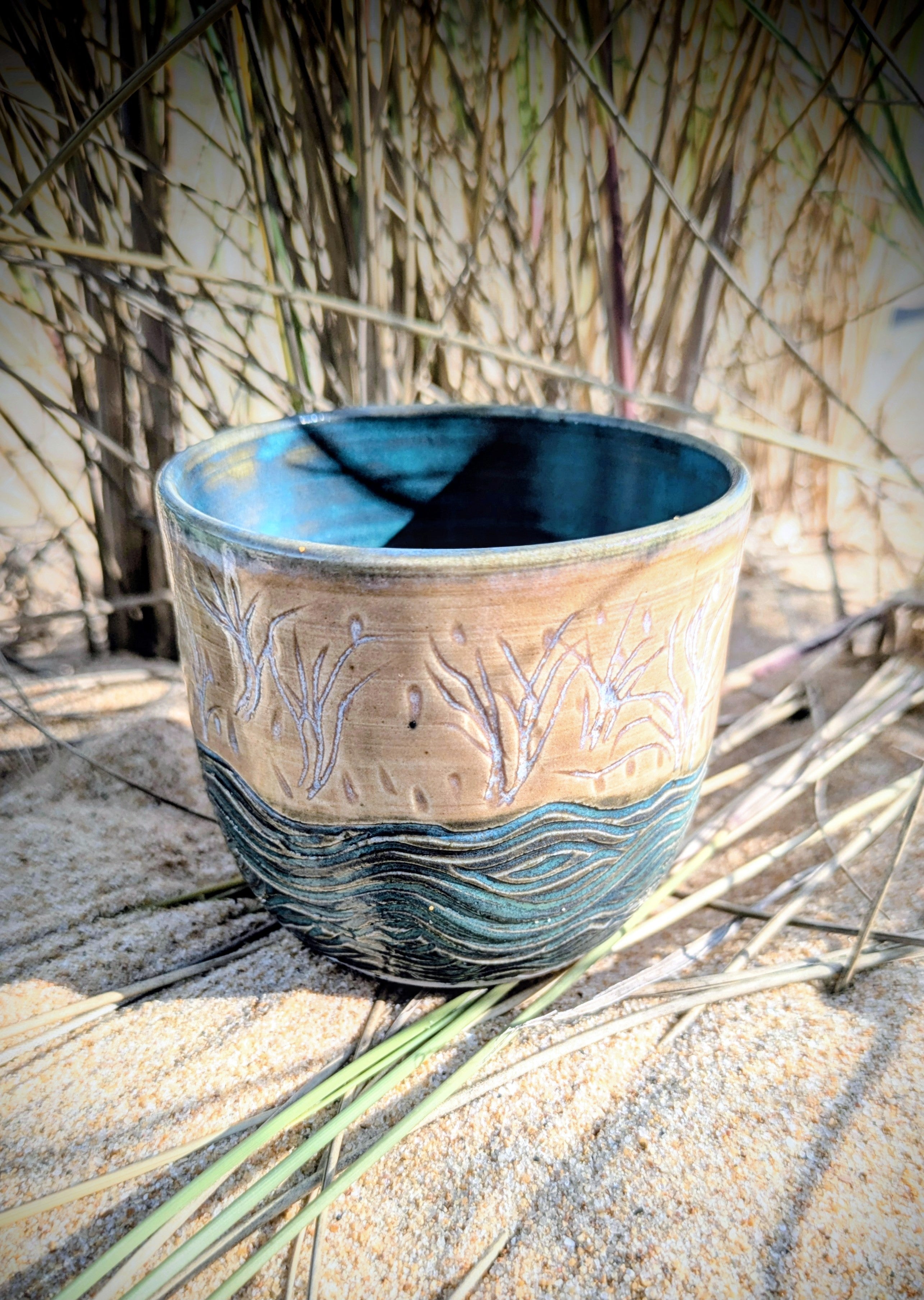 Sand dunes reeds and water tumbler