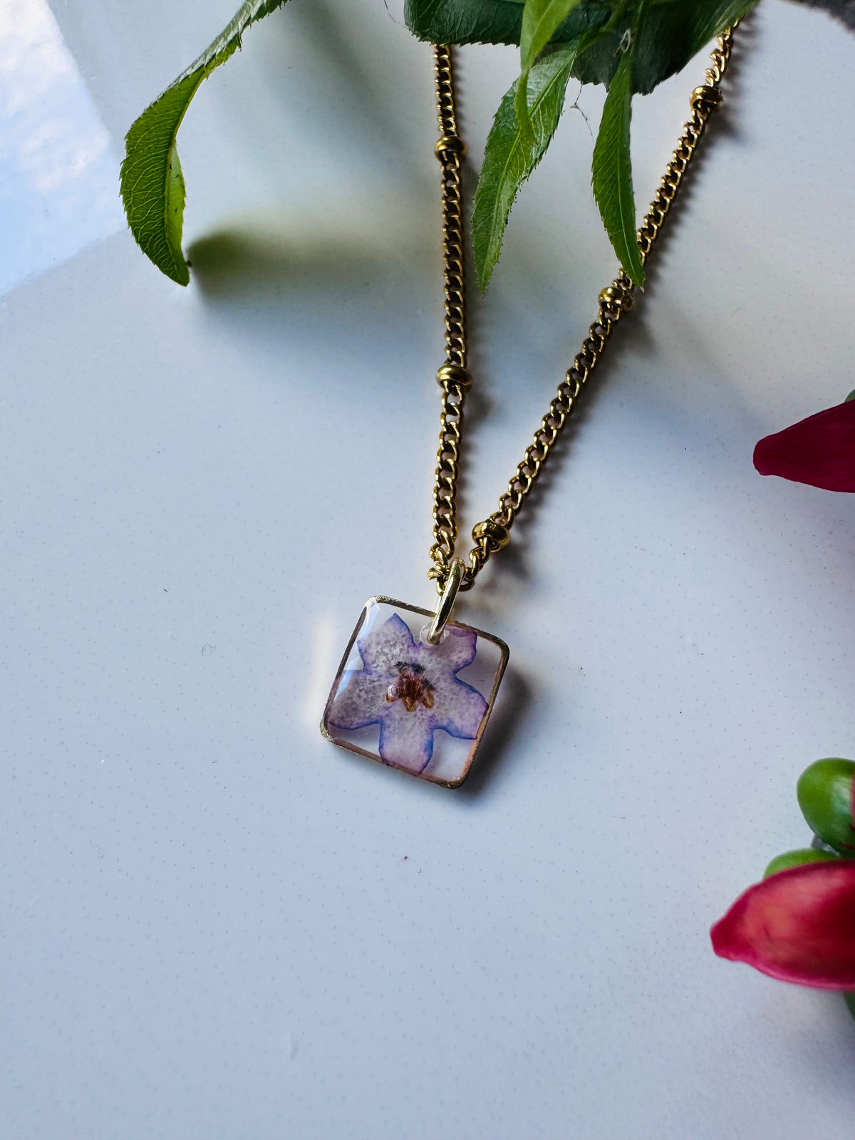 Gold plated resin necklace with purple wildflower