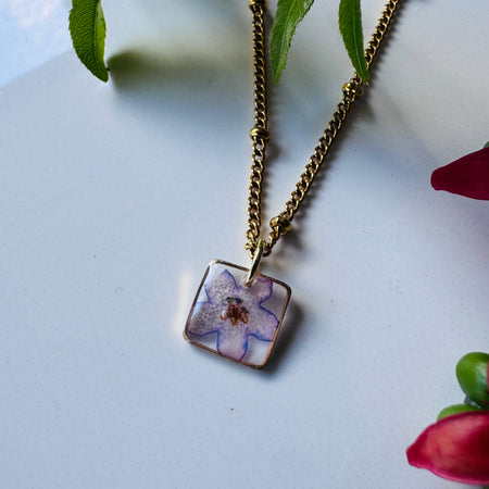 Gold plated resin necklace with purple wildflower