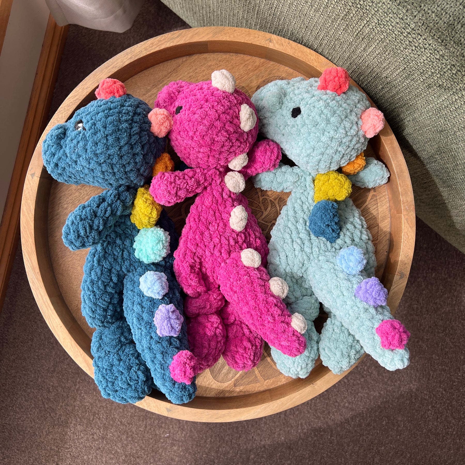Handmade crochet Dinosaur modern lovey with knotted legs and rainbow spikes.