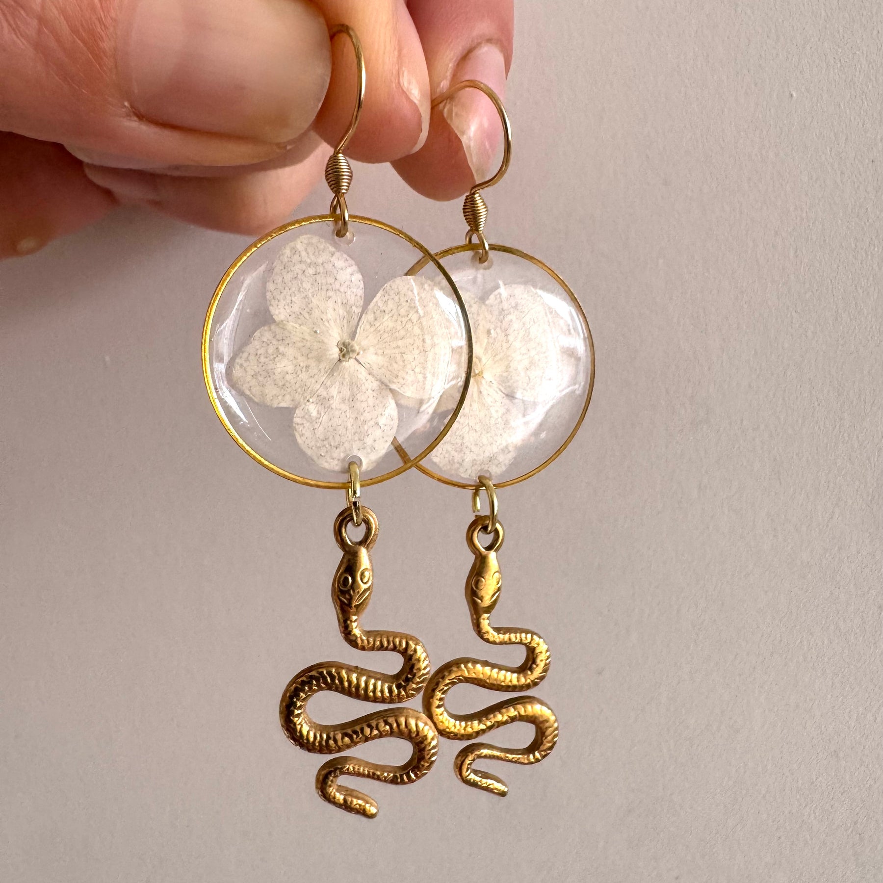 White pressed flower resin earrings with gold snake