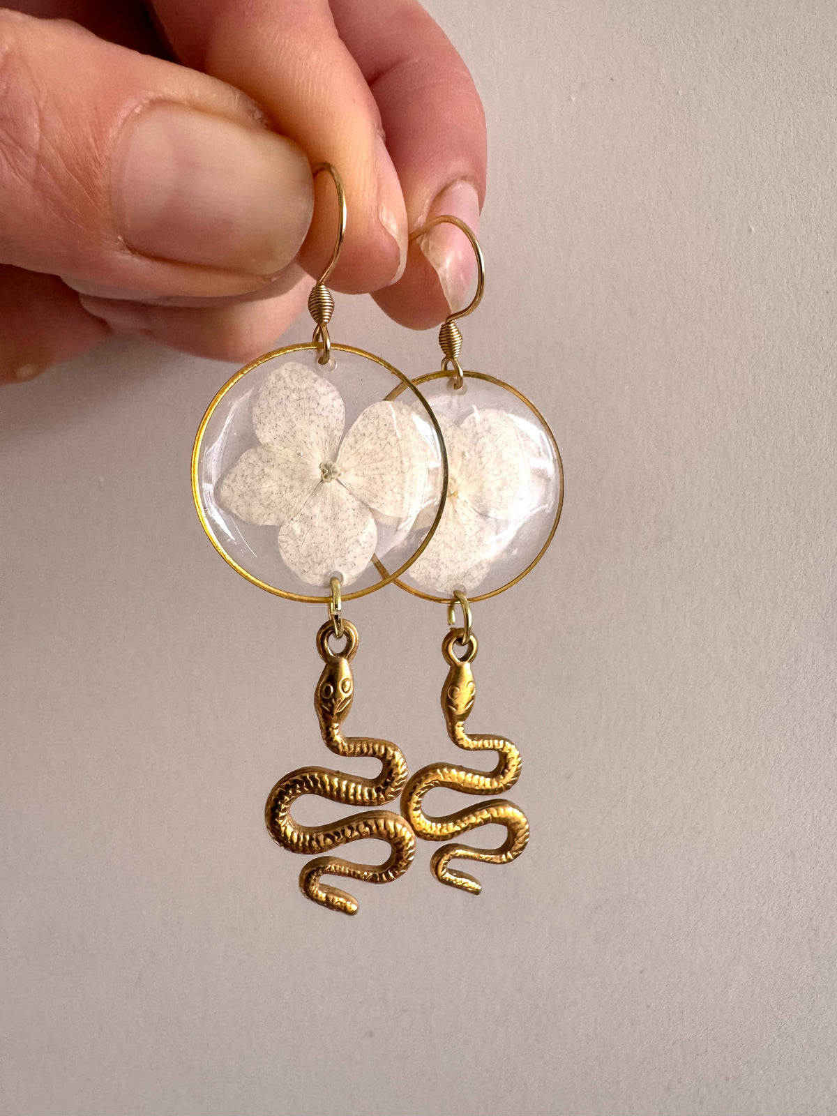 White pressed flower resin earrings with gold snake