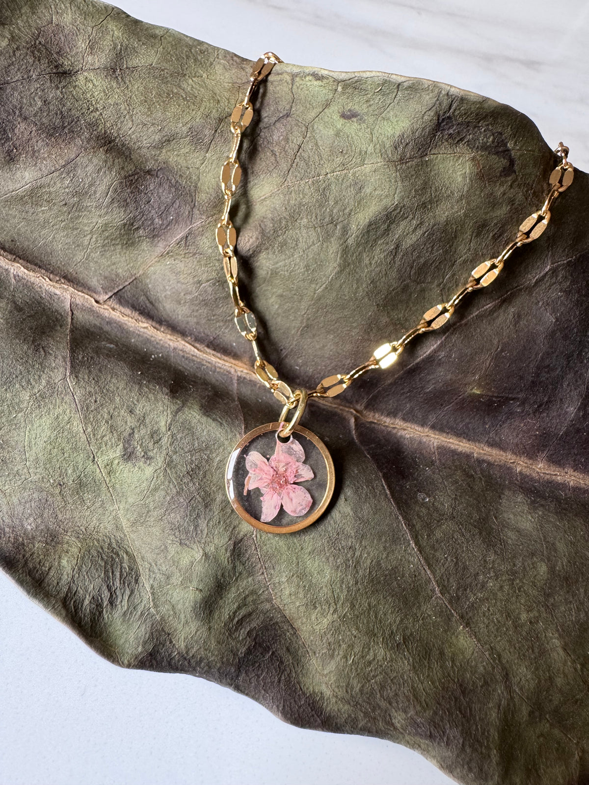 Gold plated resin necklace with pink wildflower