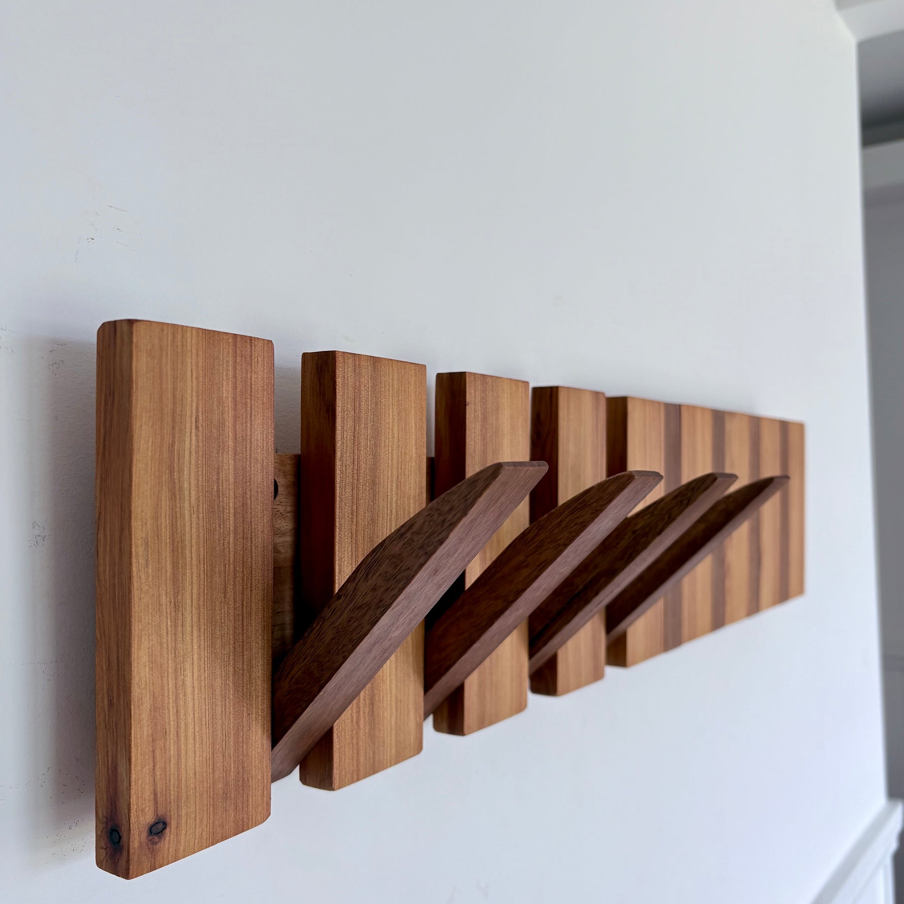Two tone spotted gum and cypress horizon line piano style coatrack