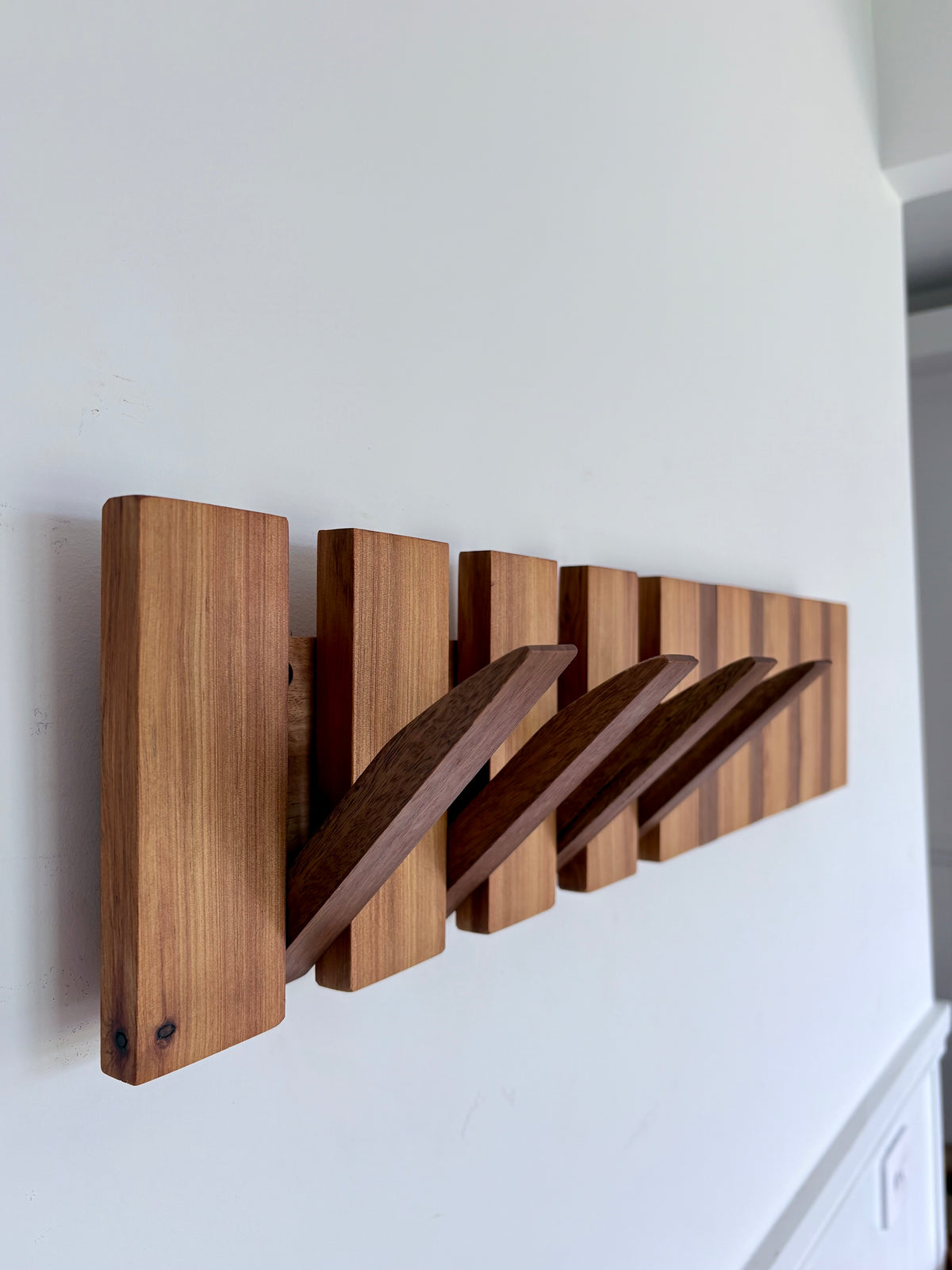 Two tone spotted gum and cypress horizon line piano style coatrack