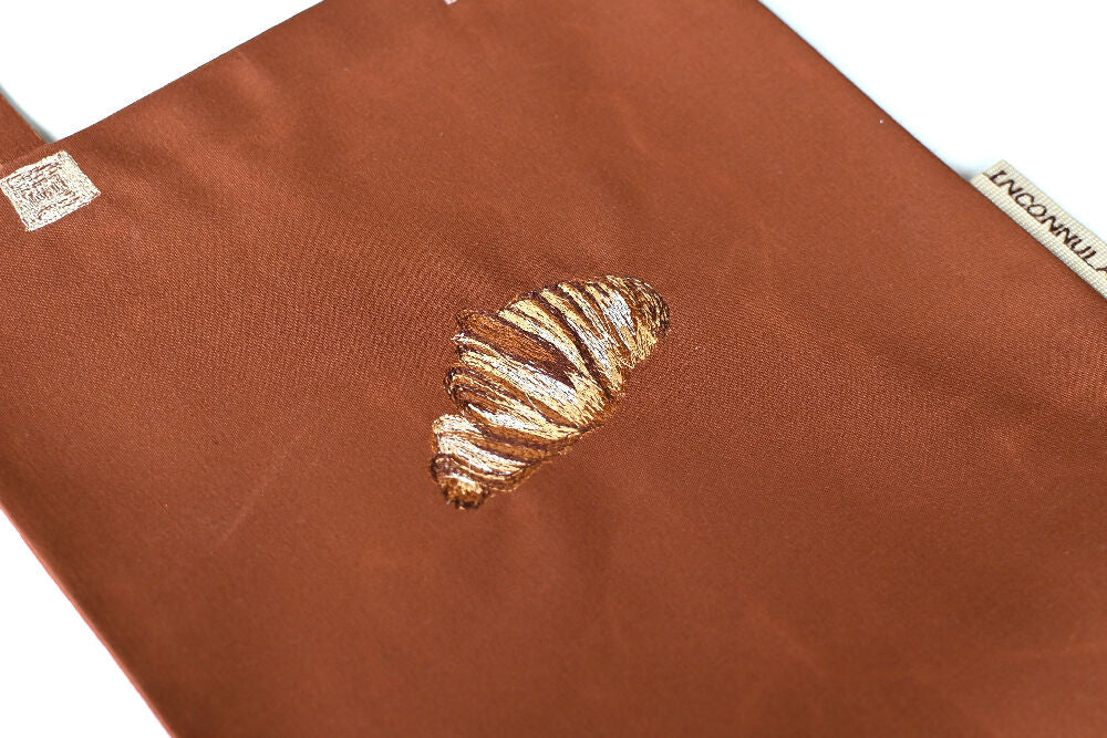 Croissant free-hand embroidery on a brown canvas