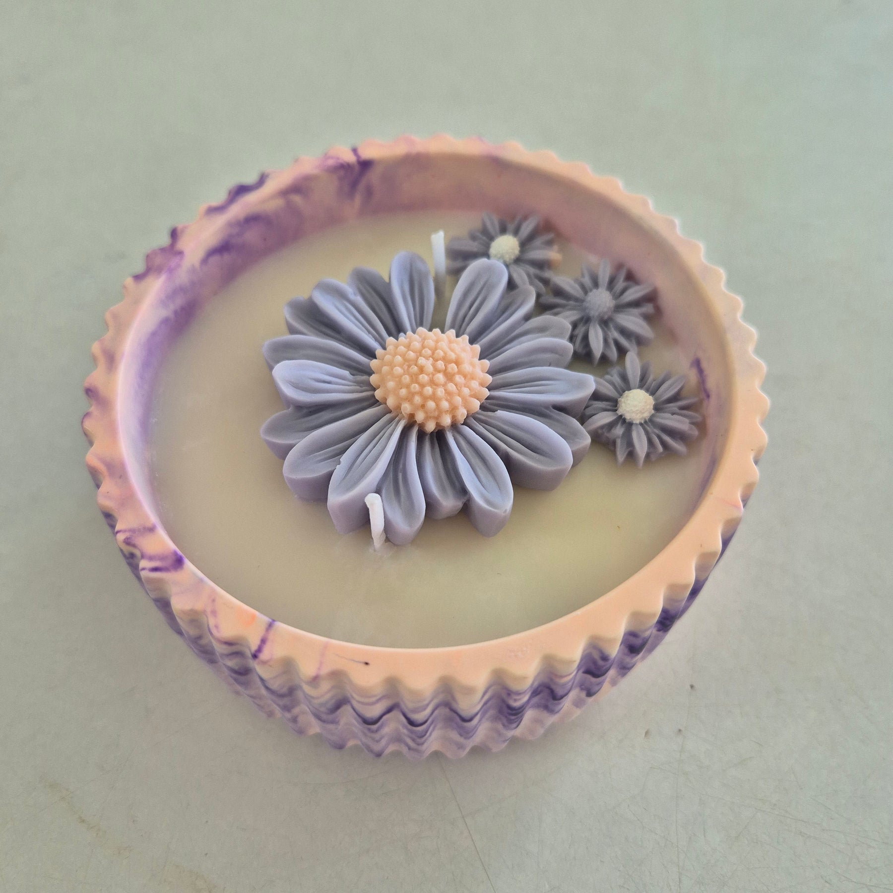Round orange and purple concrete bowl candle with rose and lavender scent