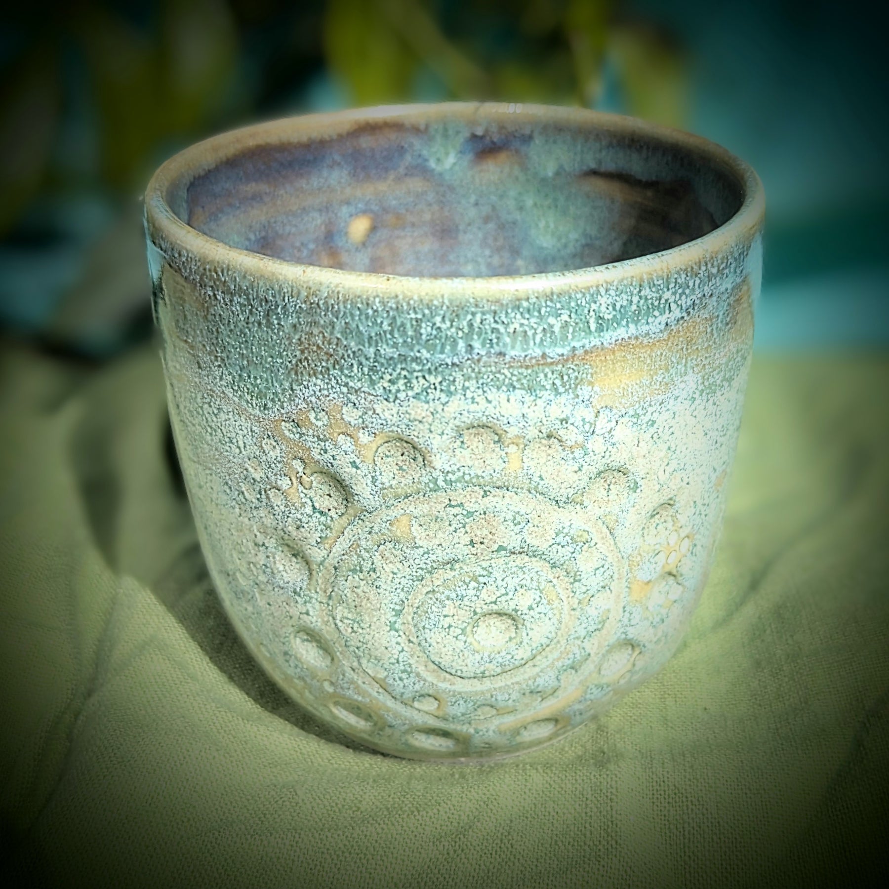 Cup in soft, mottled mossy greens and warm sandy colour