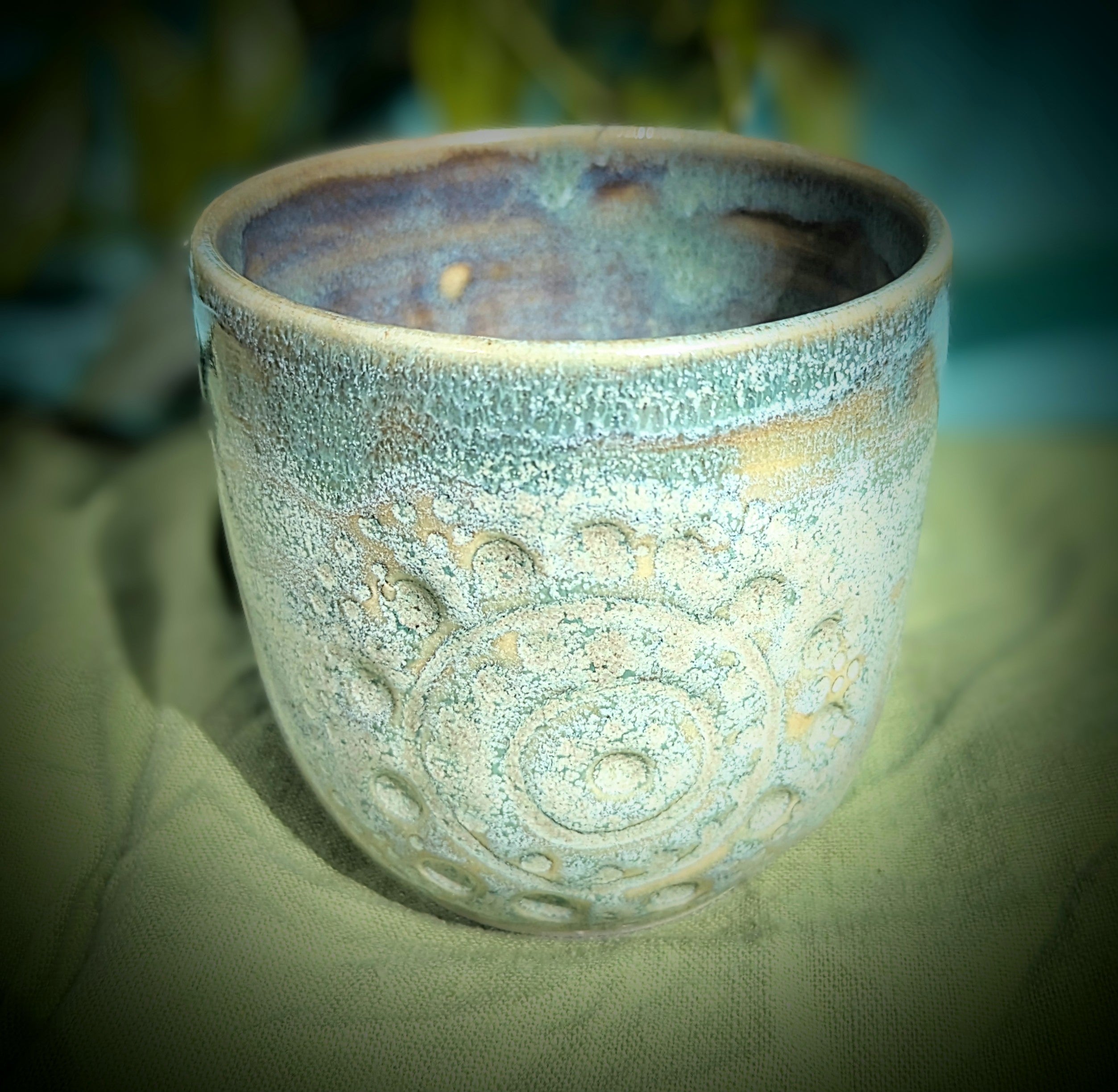 Cup in soft, mottled mossy greens and warm sandy colour