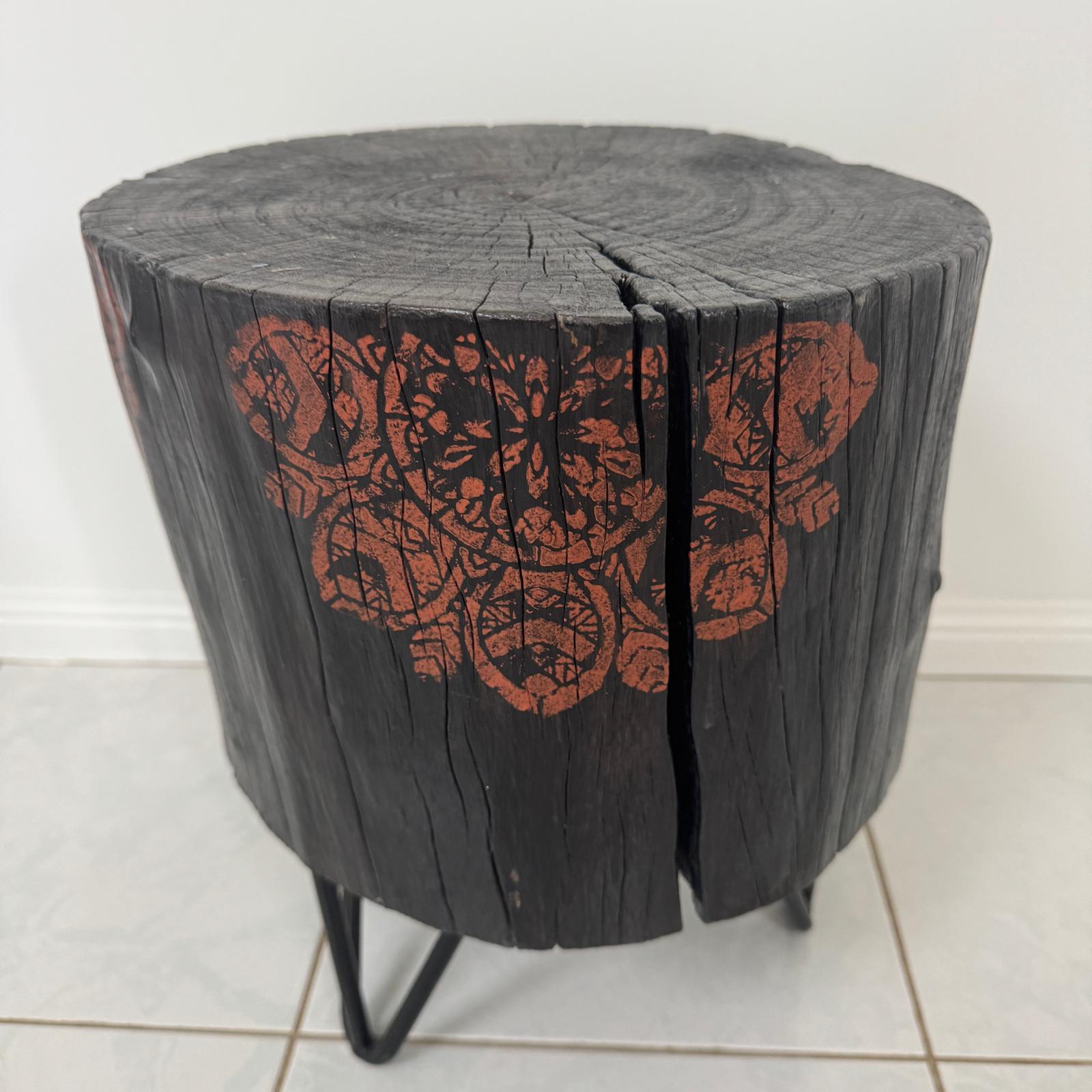 Burnt timber stump table featuring copper mandala artwork