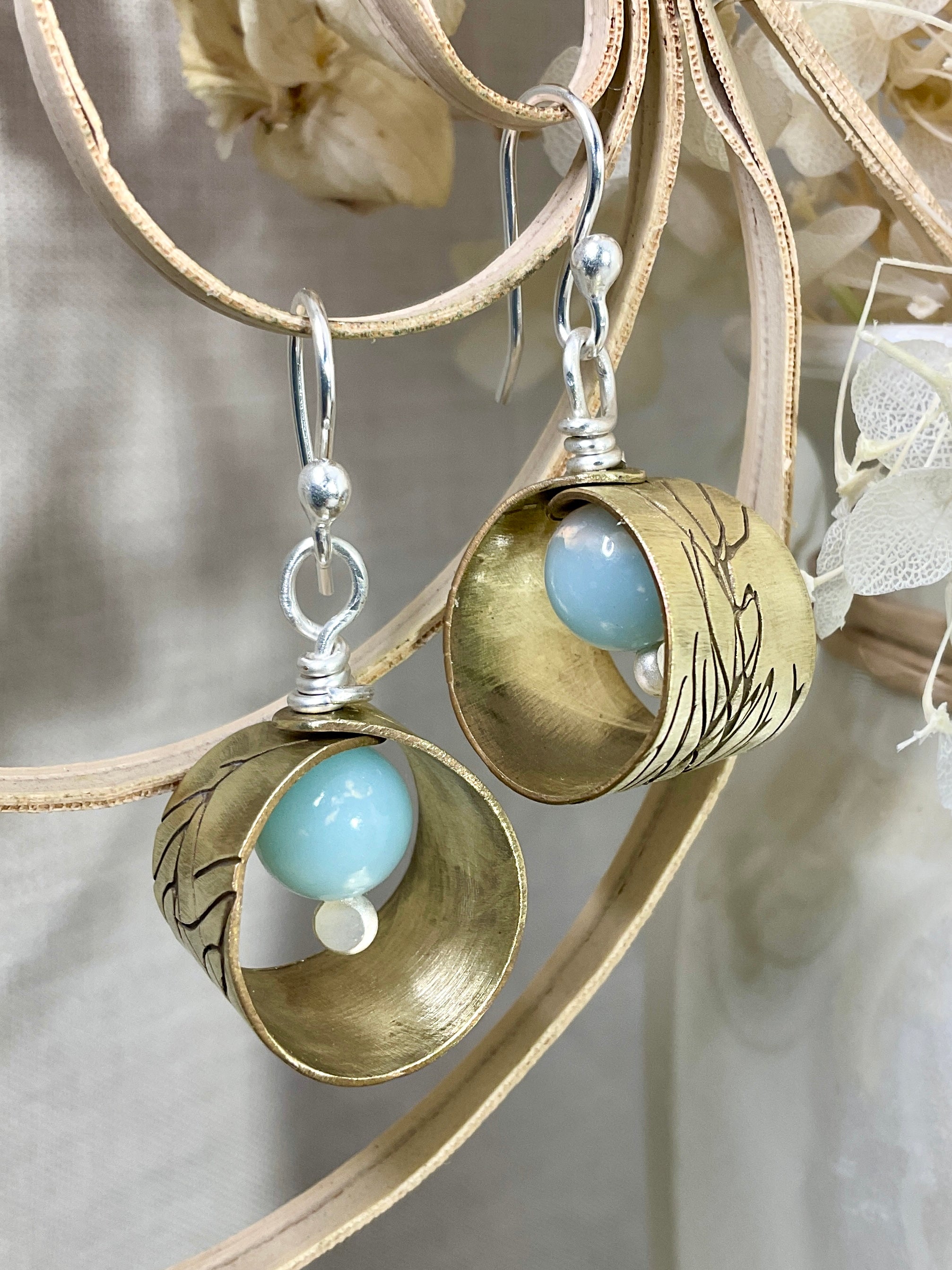Embossed brass earrings with gemstones.
