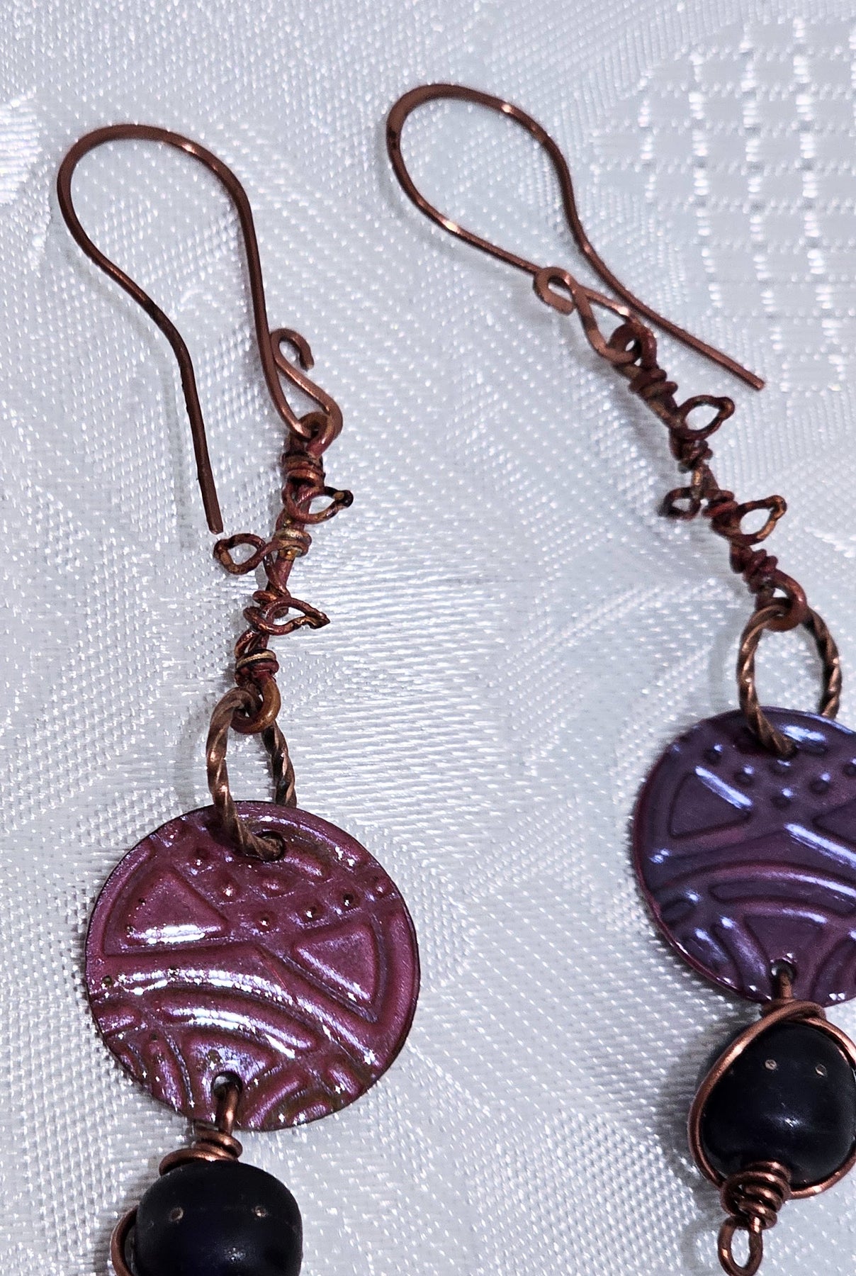 Suspended Pressed Metal Discs with Barbed Wirework Link and Black Matt Lampwork bead