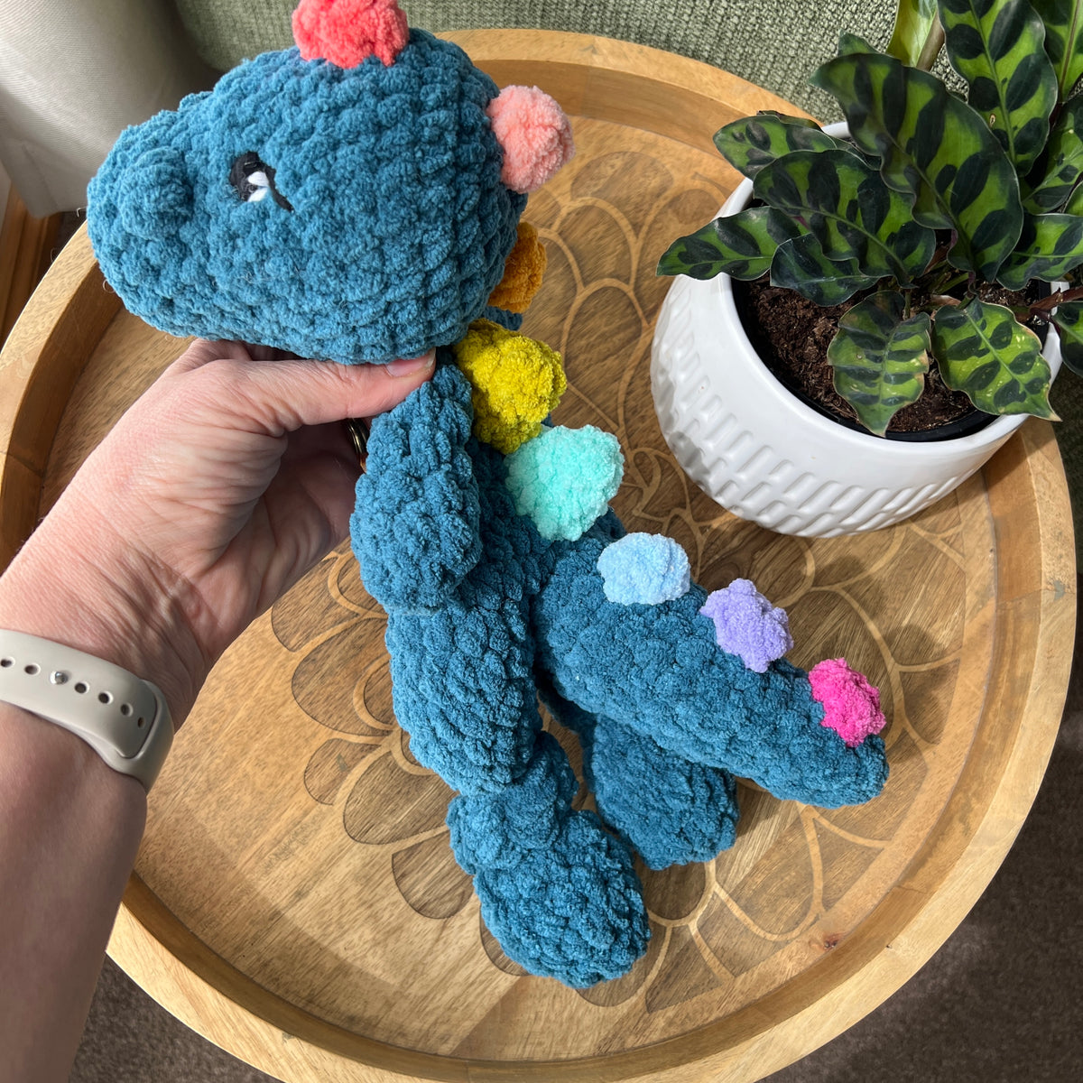 Handmade crochet Dinosaur modern lovey with knotted legs and rainbow spikes.