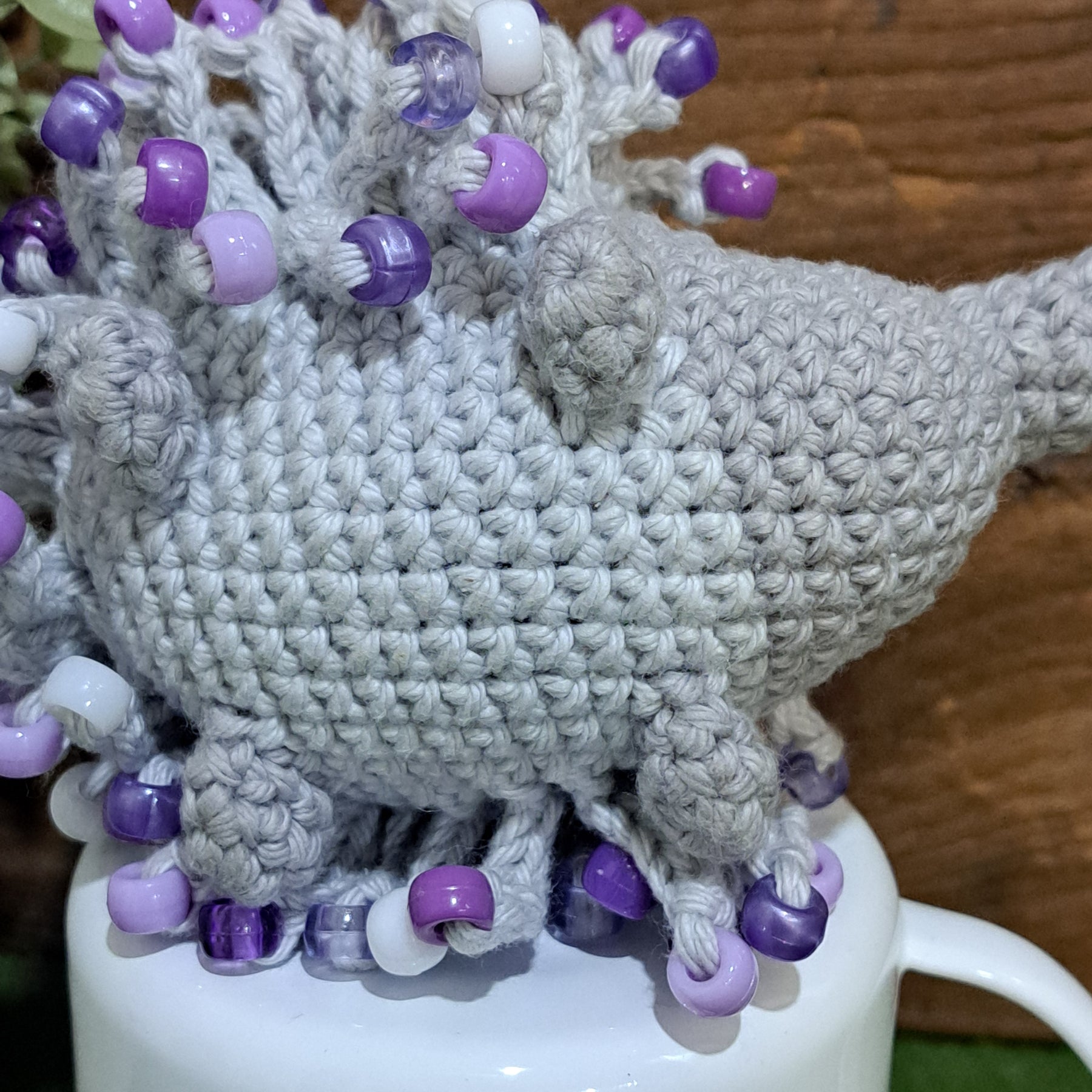 Handmade crochet echidna in grey cotton with mauve beads