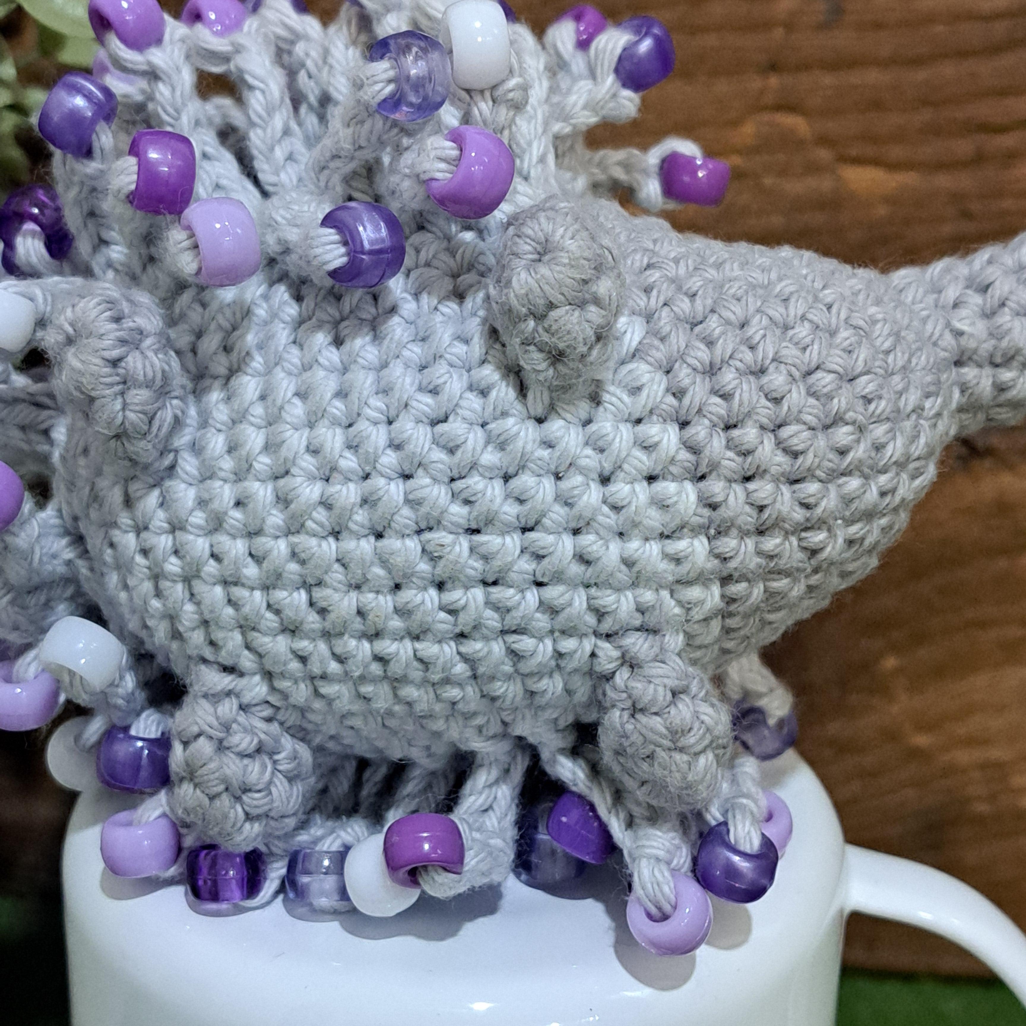 Handmade crochet echidna in grey cotton with mauve beads