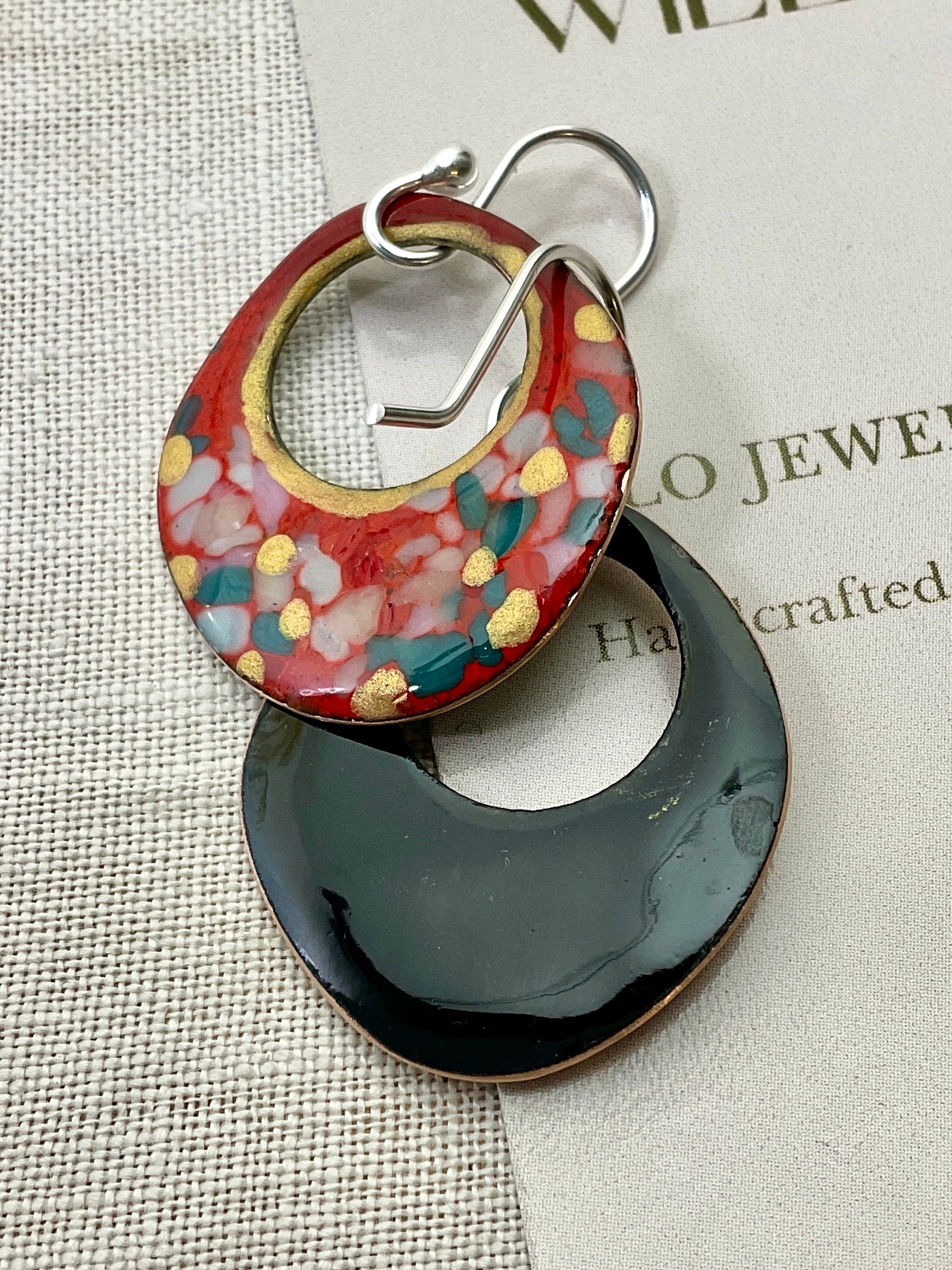 Red enamel earrings with glass specks and gold accents.