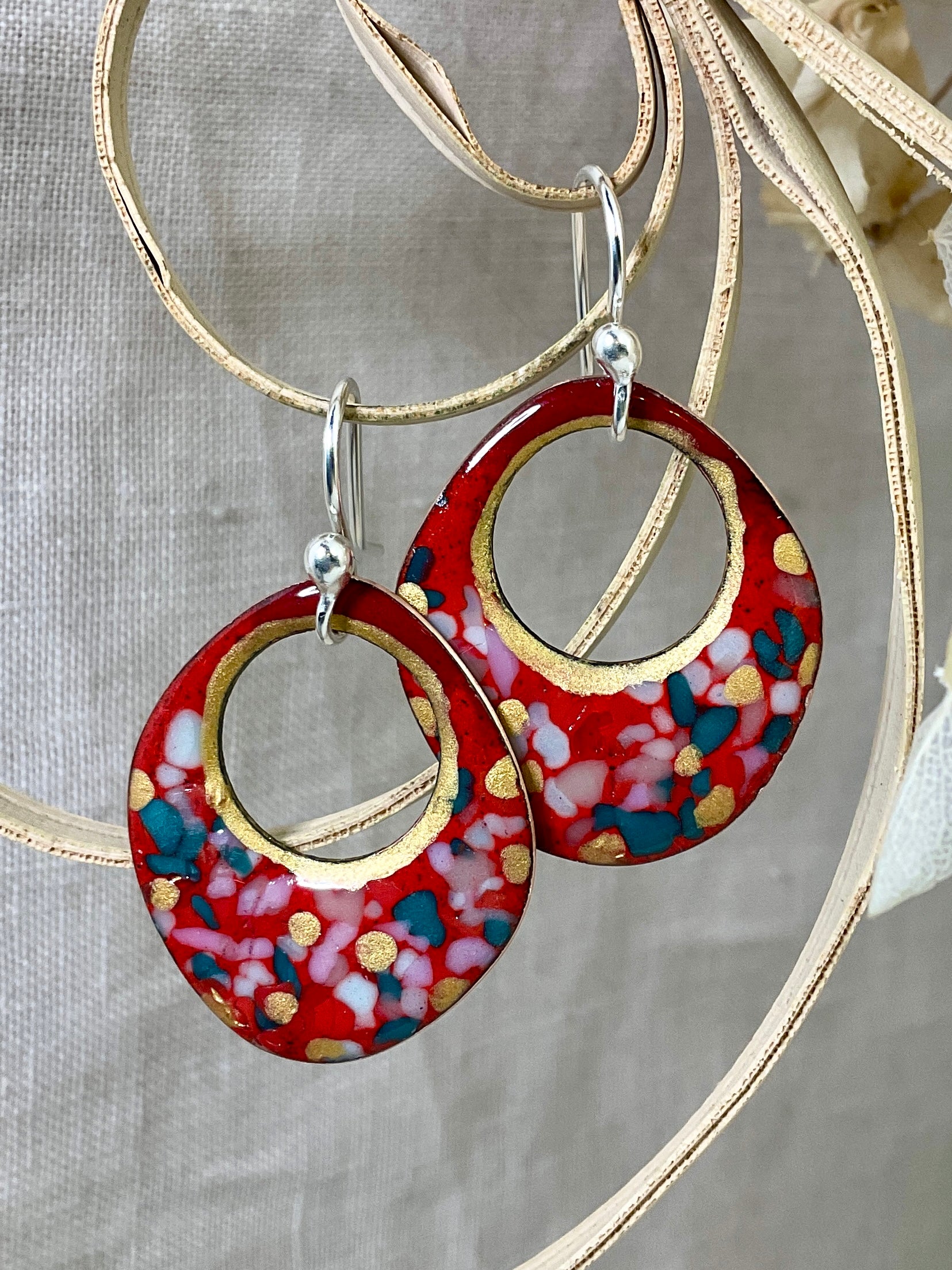 Red enamel earrings with glass specks and gold accents.