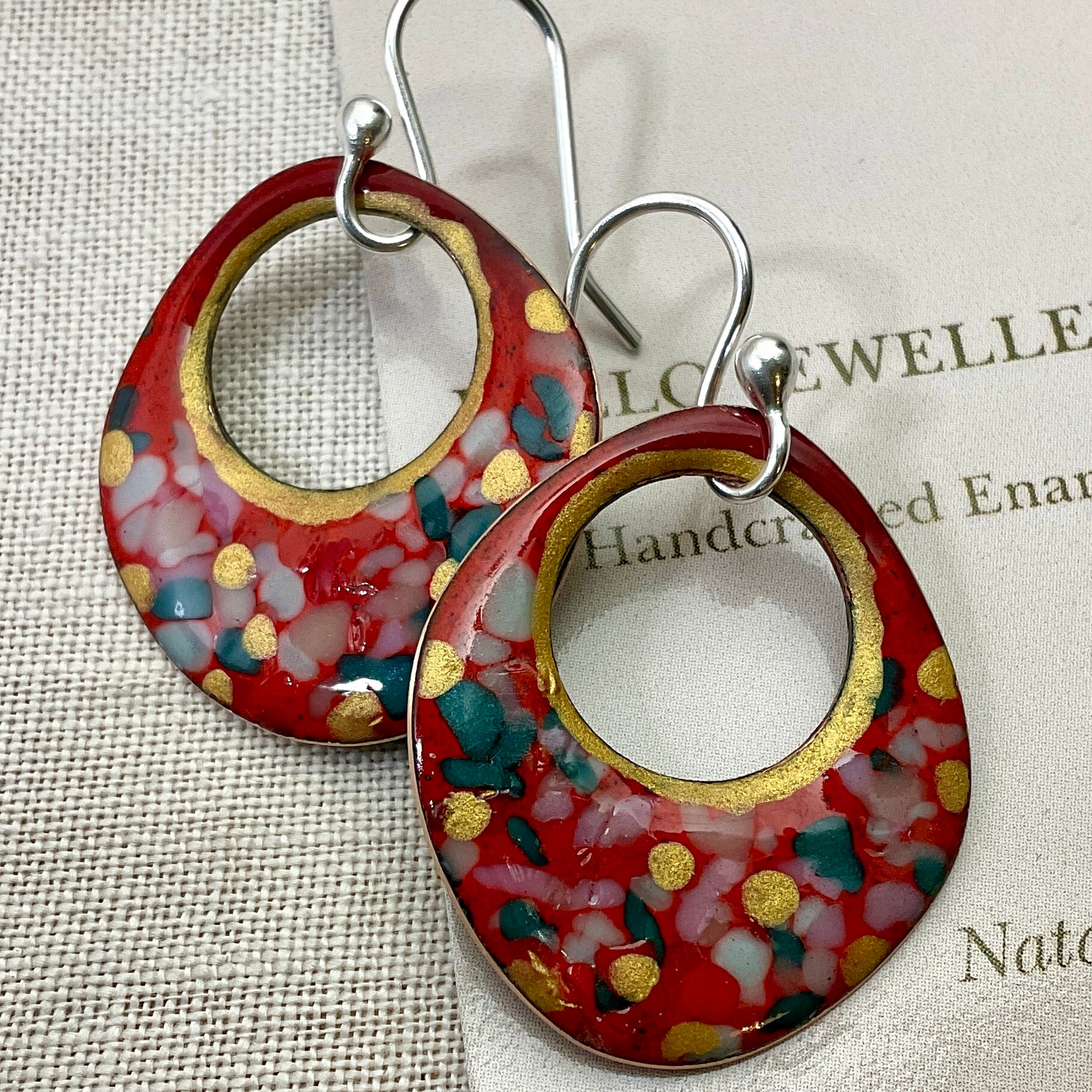 Red enamel earrings with glass specks and gold accents.