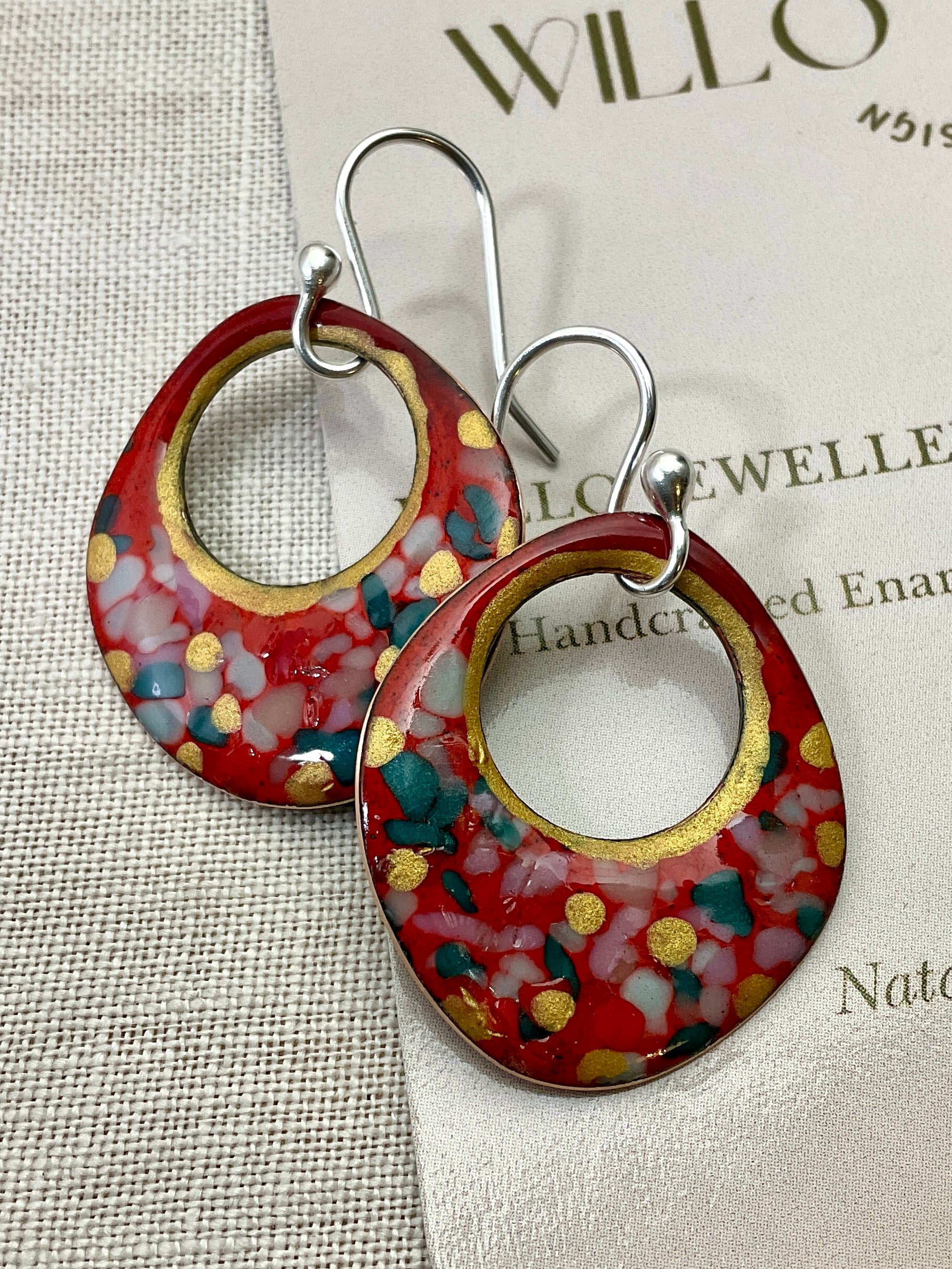 Red enamel earrings with glass specks and gold accents.