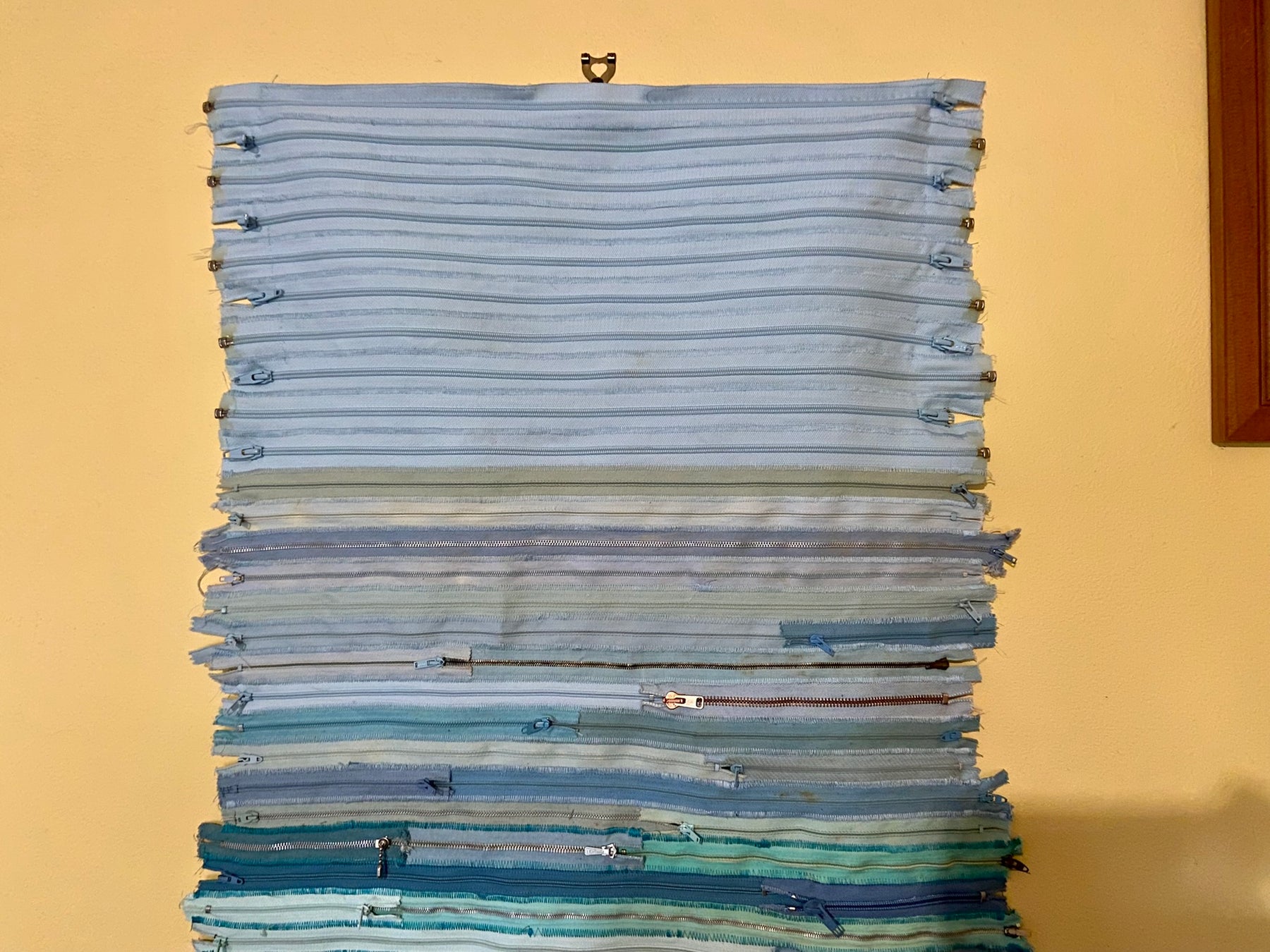 Upcycled 90 zips textile wall hanging. Ocean & Sky theme. Adorned with charms. Blue colour scheme. Ready to hang includes 2 x dowel rods