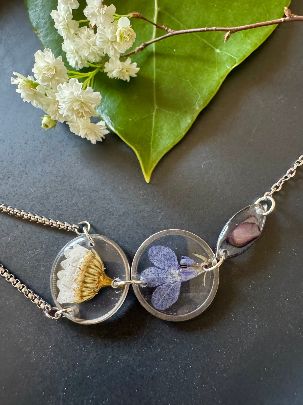 Botanical resin hand chain in silver with pressed flowers and cowrie shell