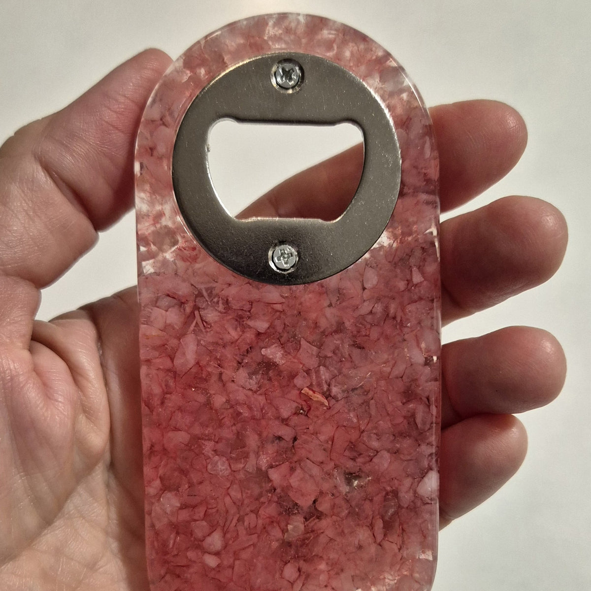 Resin bottle opener with inlaid rose quartz stones