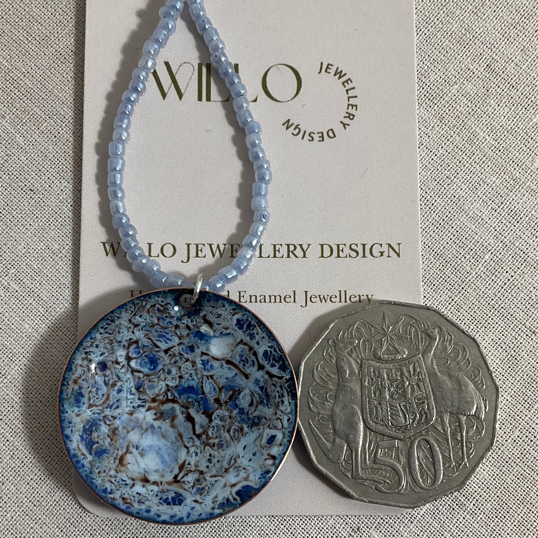 Blue enamel pendant on glass seed bead necklace.