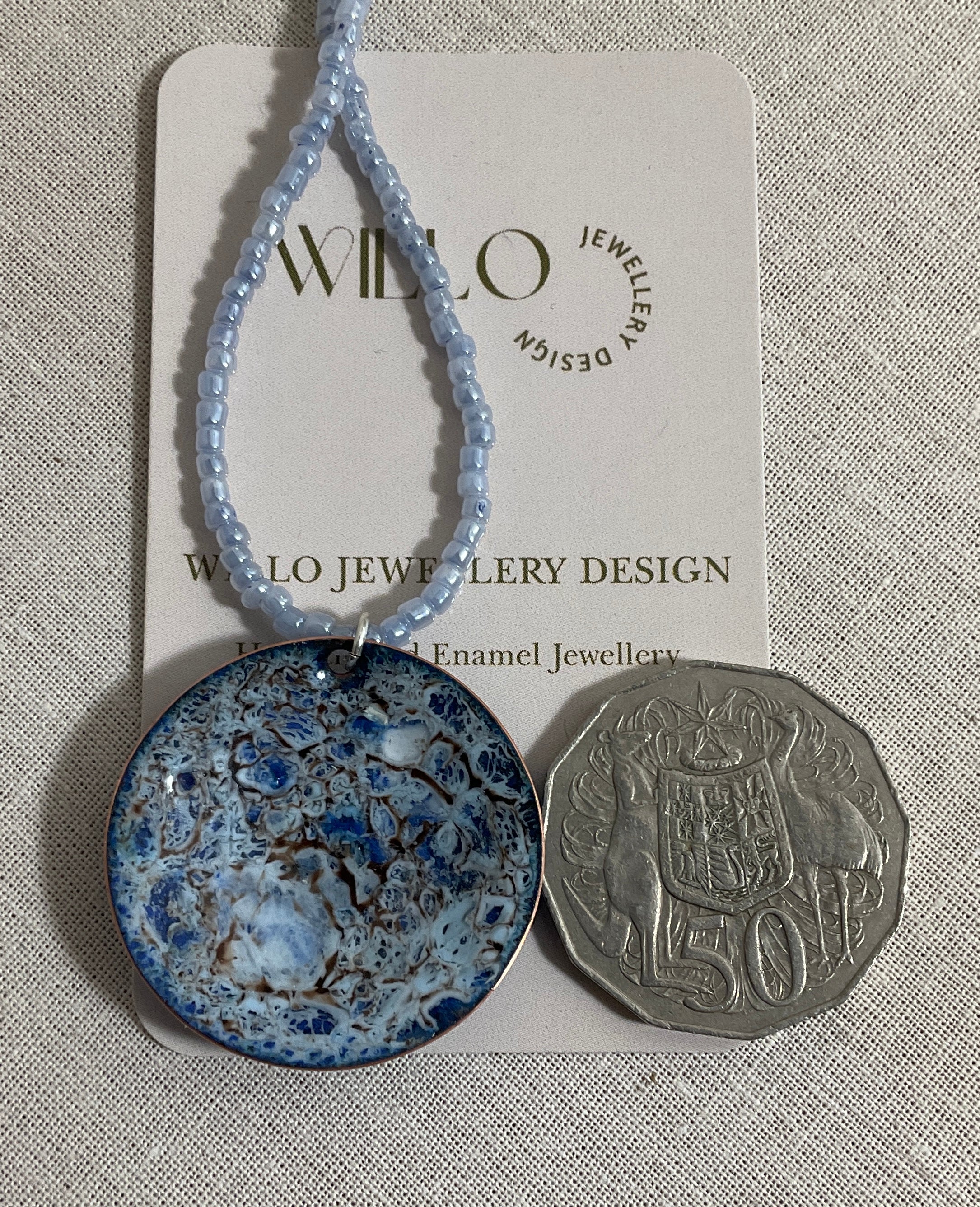 Blue enamel pendant on glass seed bead necklace.