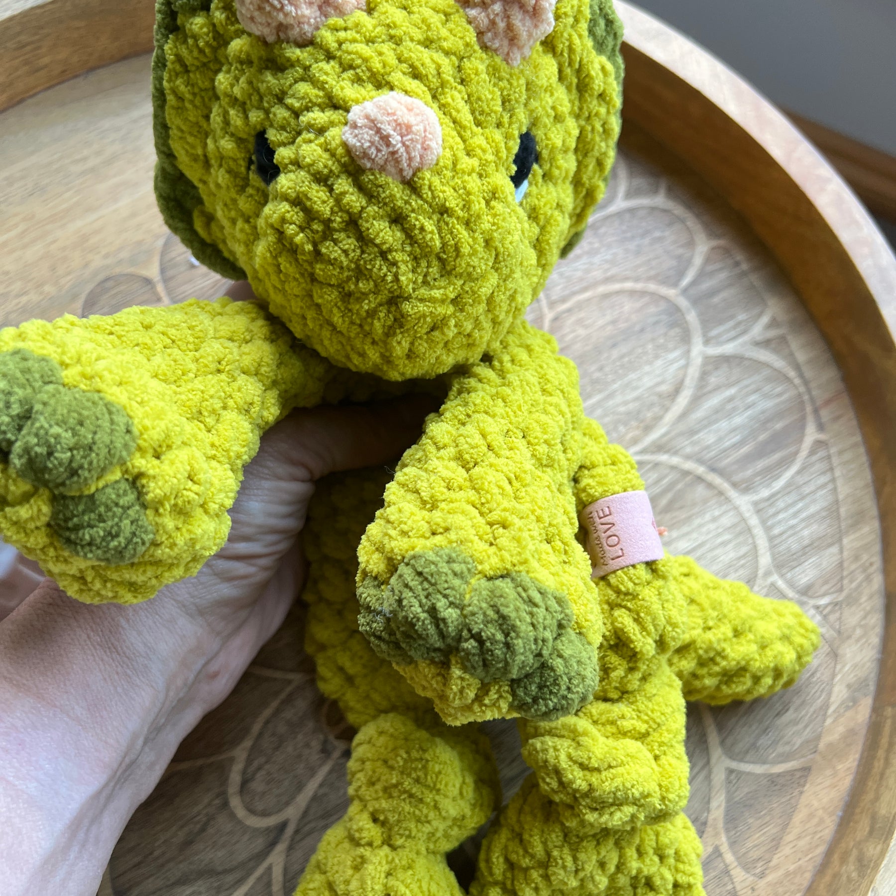 Handmade modern crochet Triceratops lovey snuggler with knotted legs baby safe.