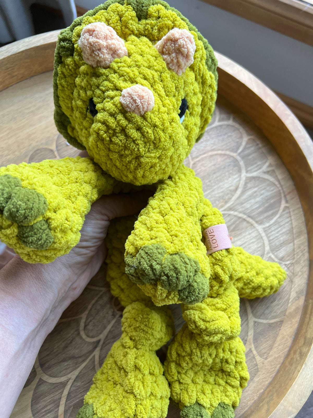 Handmade modern crochet Triceratops lovey snuggler with knotted legs baby safe.