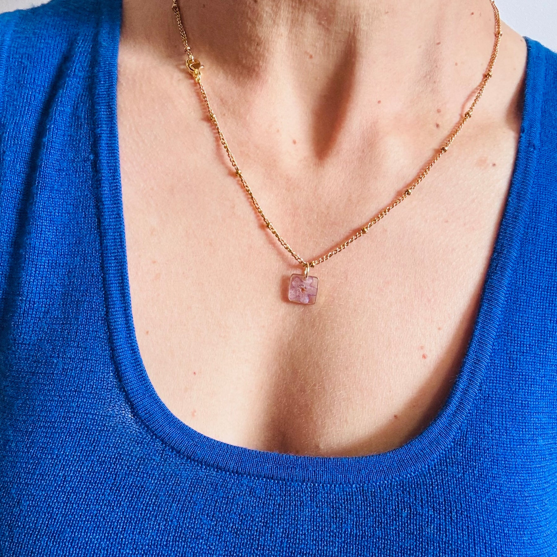 Gold plated resin necklace with purple wildflower