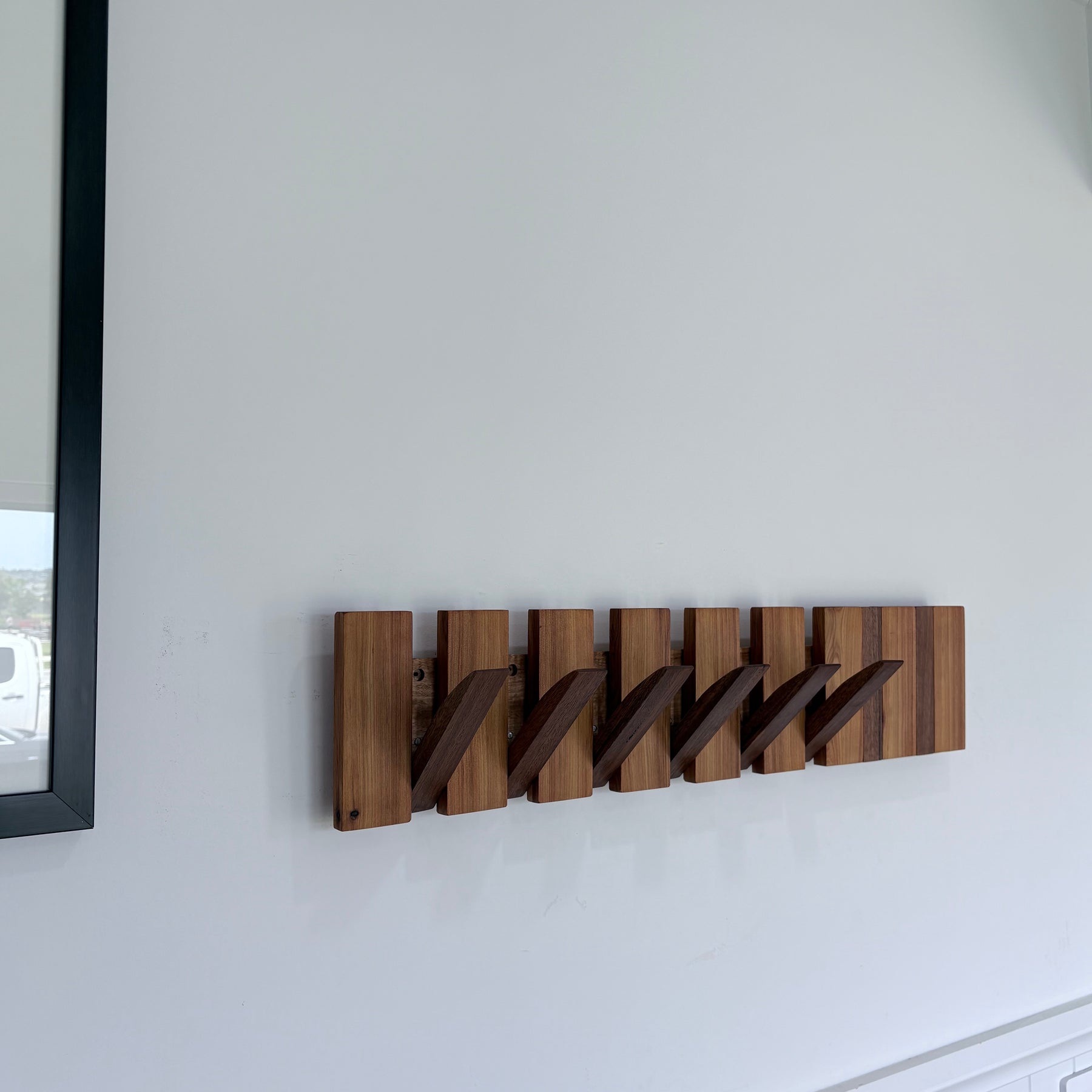 Two tone spotted gum and cypress horizon line piano style coatrack