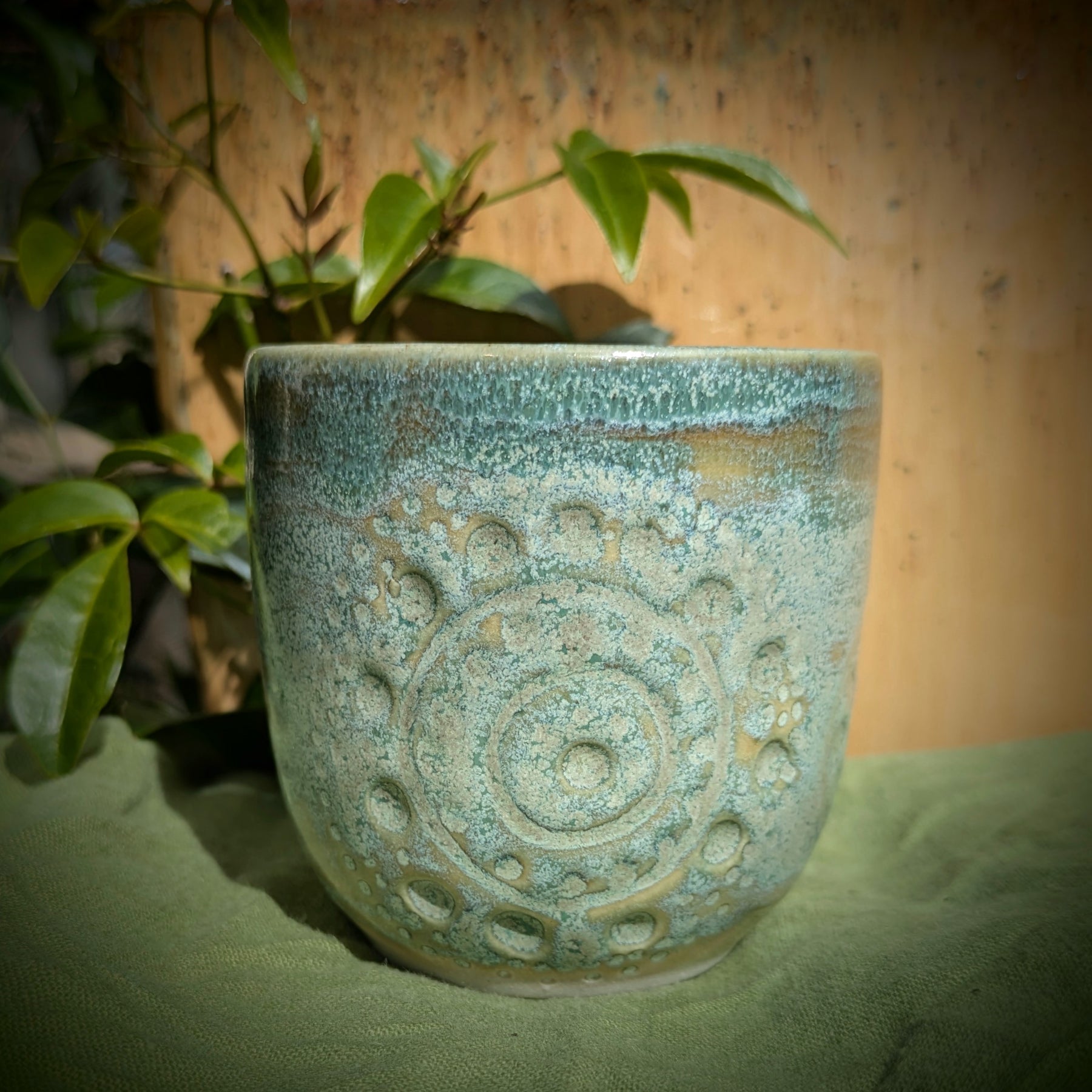 Cup in soft, mottled mossy greens and warm sandy colour