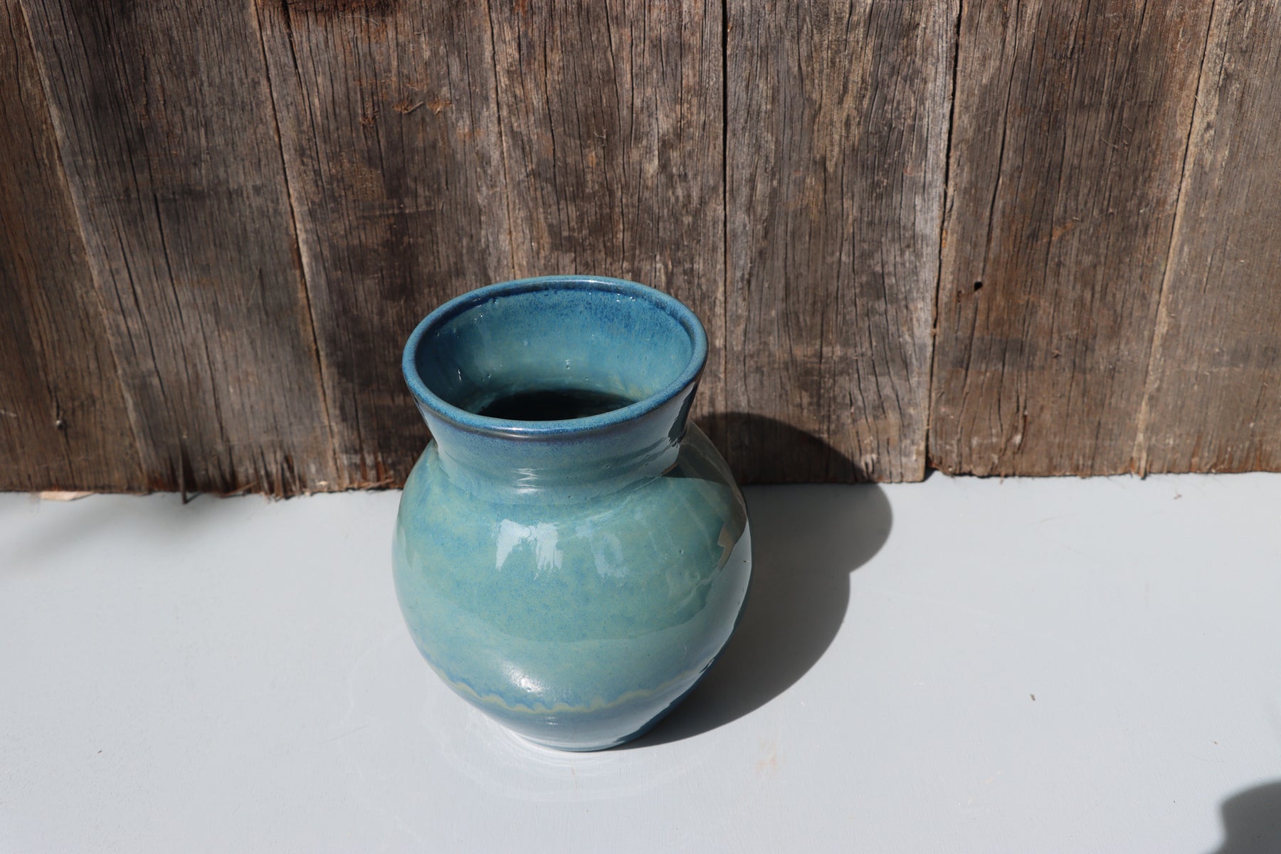 Large blue stoneware vase with blue green speckled glaze on buff clay