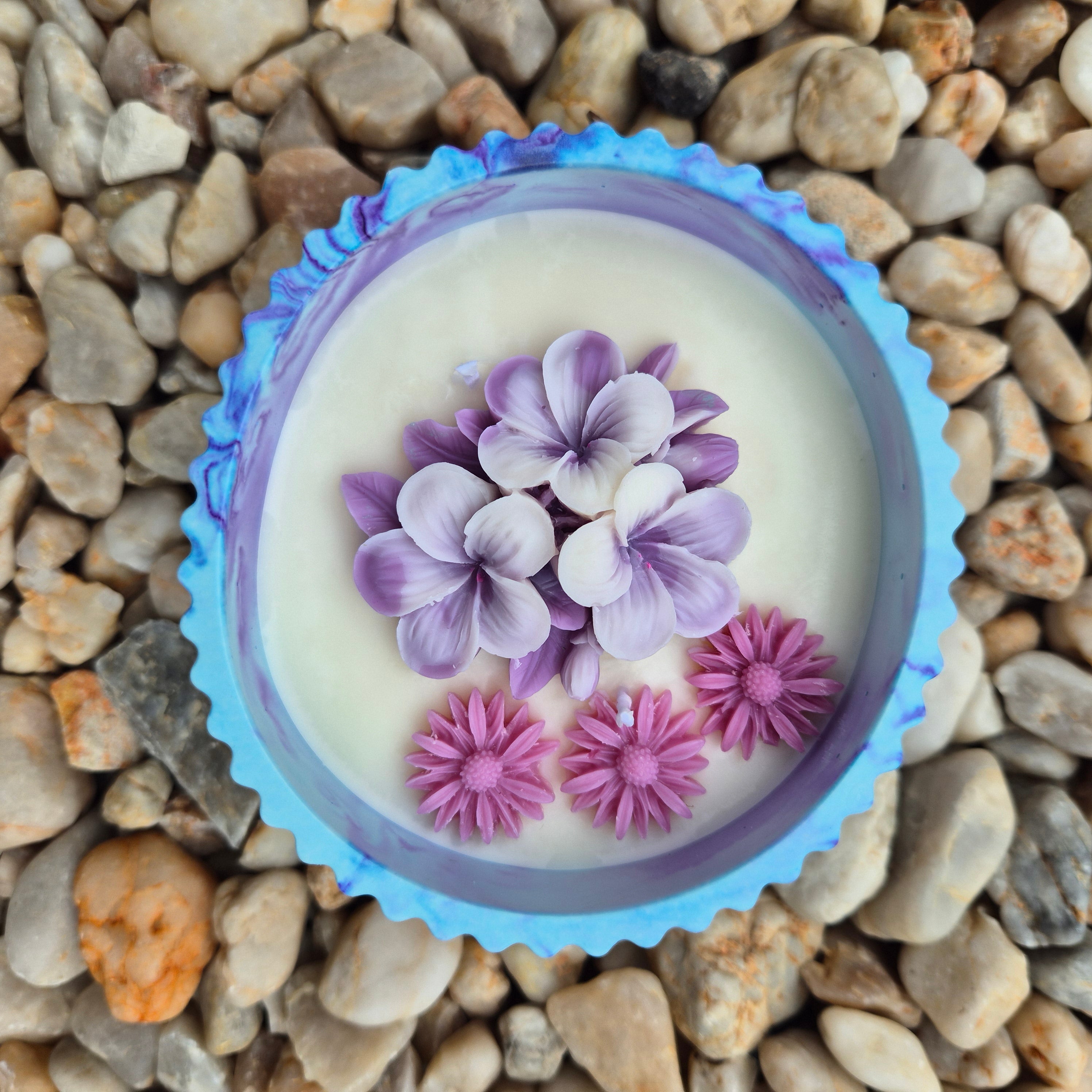 Round blue and purple concrete bowl candle with frangipani flower