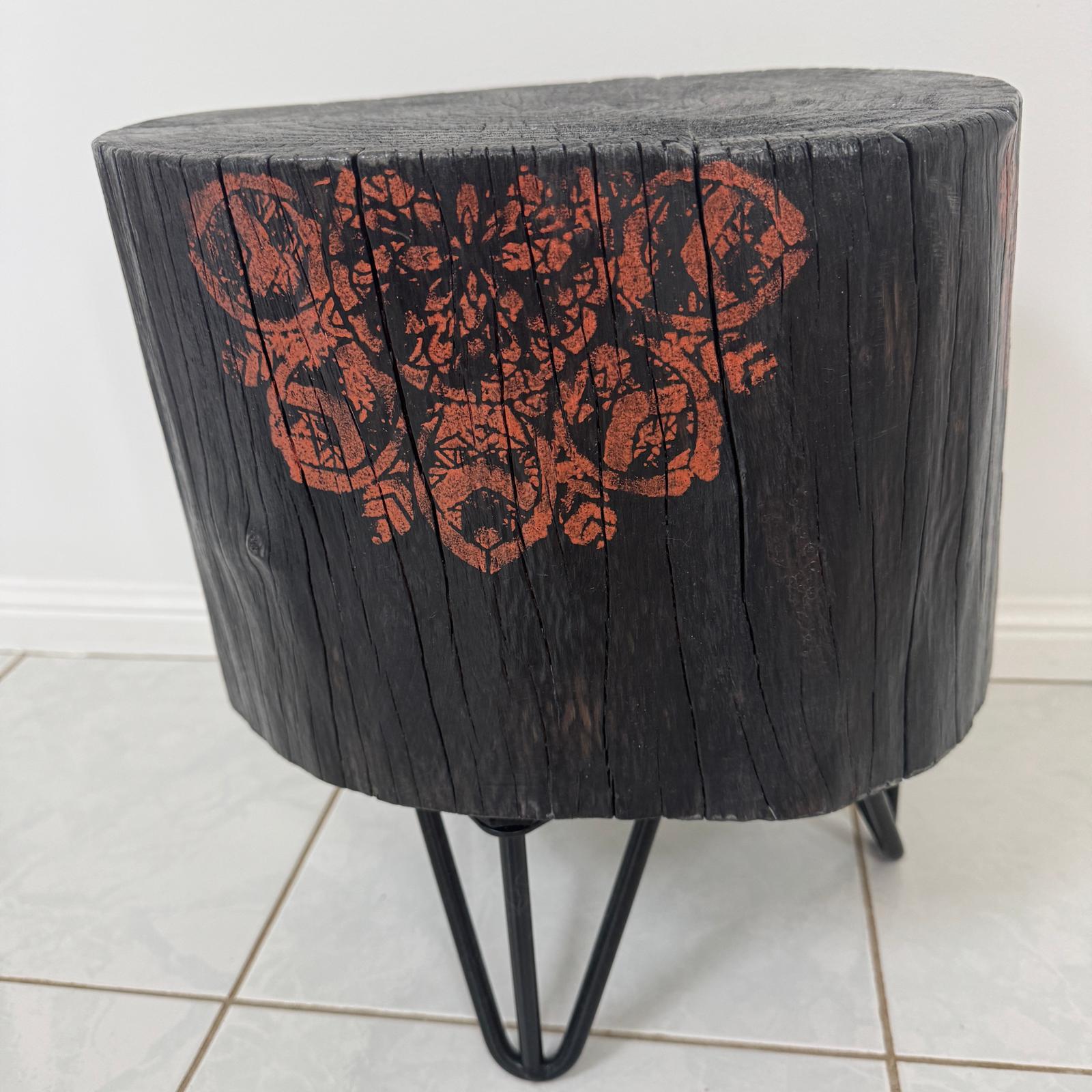 Burnt timber stump table featuring copper mandala artwork