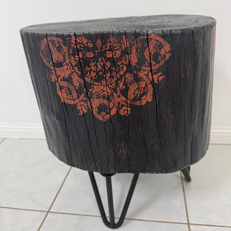 Burnt timber stump table featuring copper mandala artwork