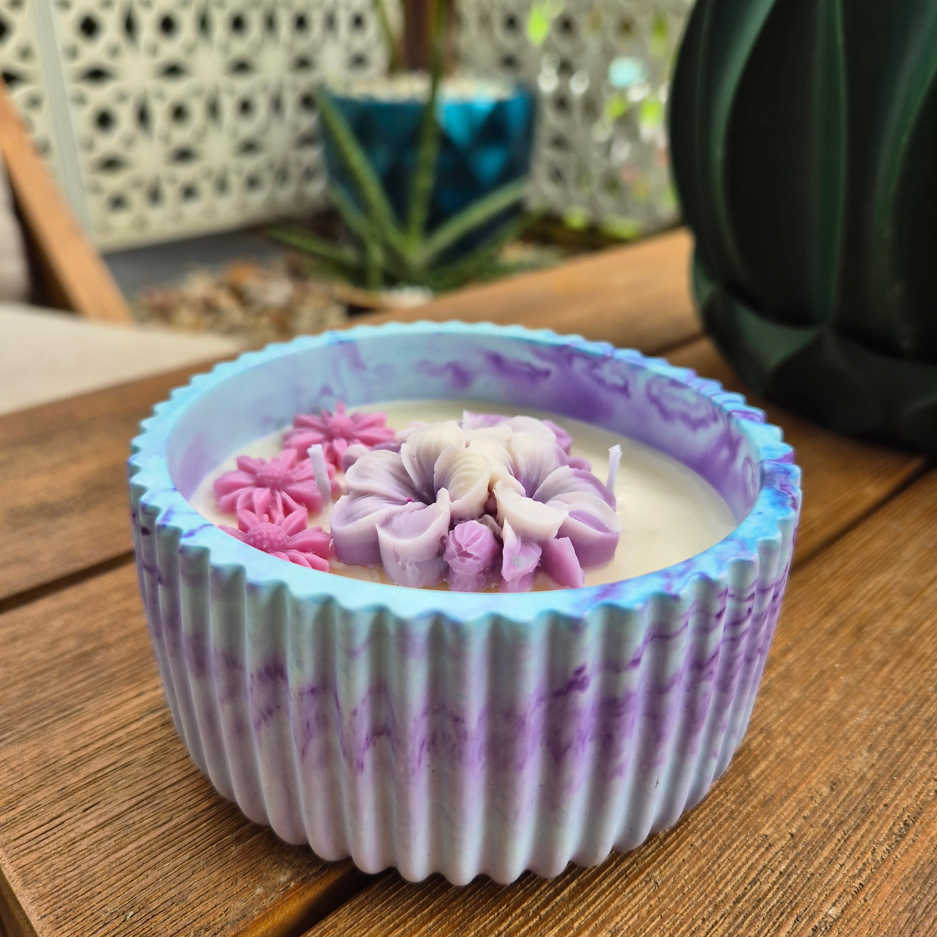 Round blue and purple concrete bowl candle with frangipani flower