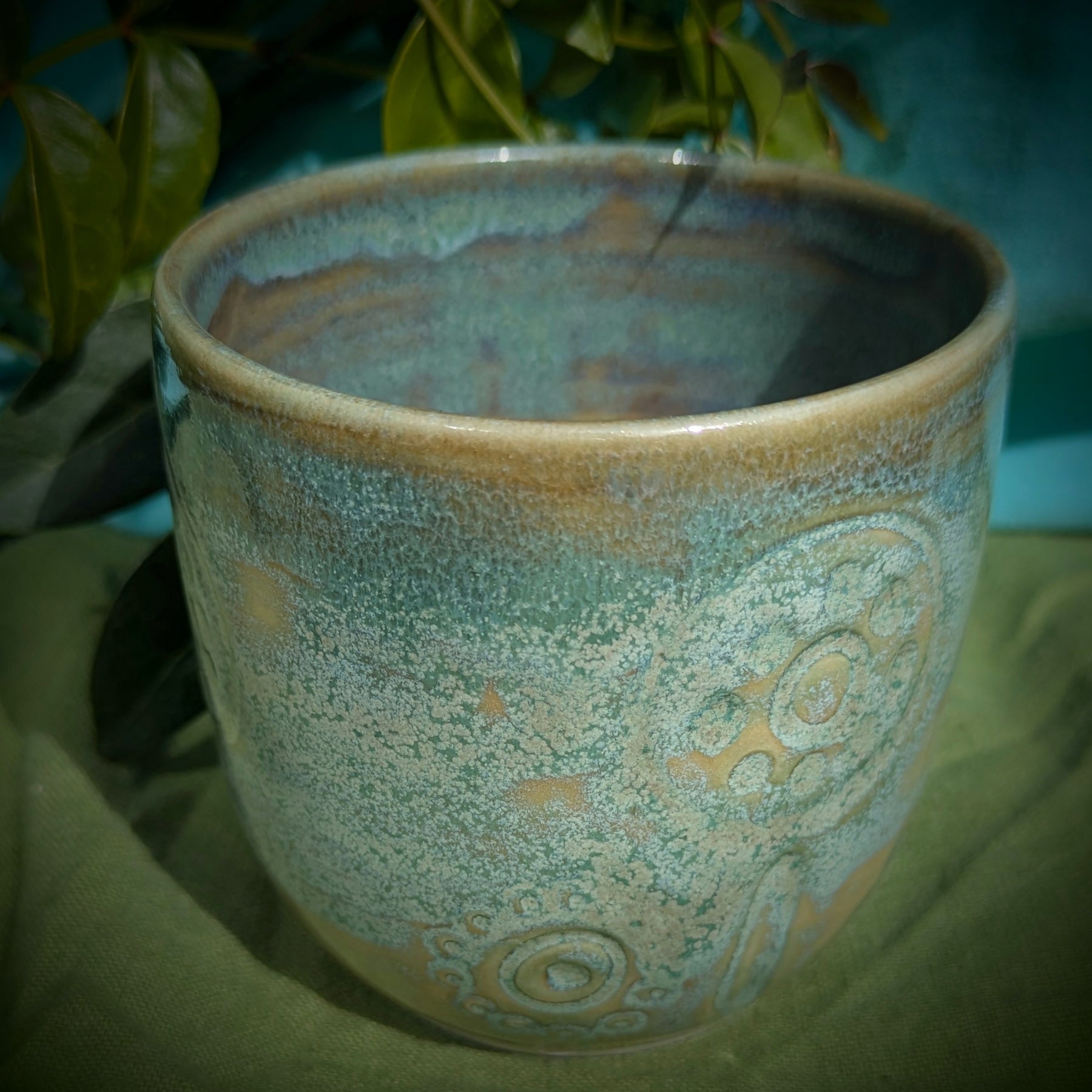 Cup in soft, mottled mossy greens and warm sandy colour