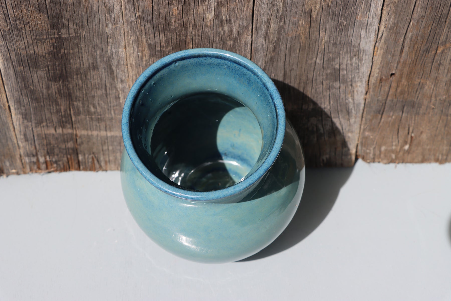 Large blue stoneware vase with blue green speckled glaze on buff clay