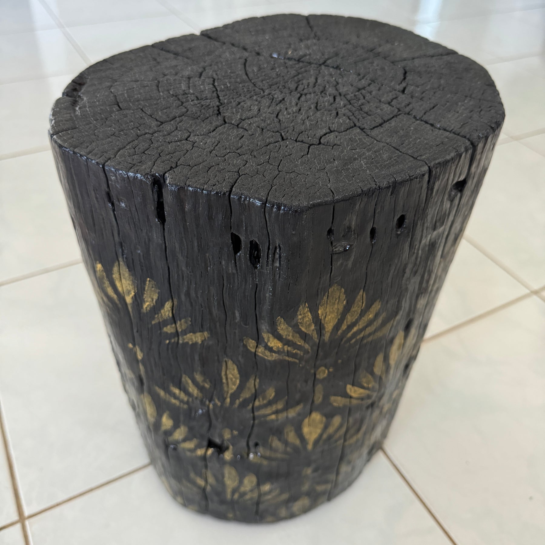 Burnt Timber stump table featuring gold hand-painted artwork