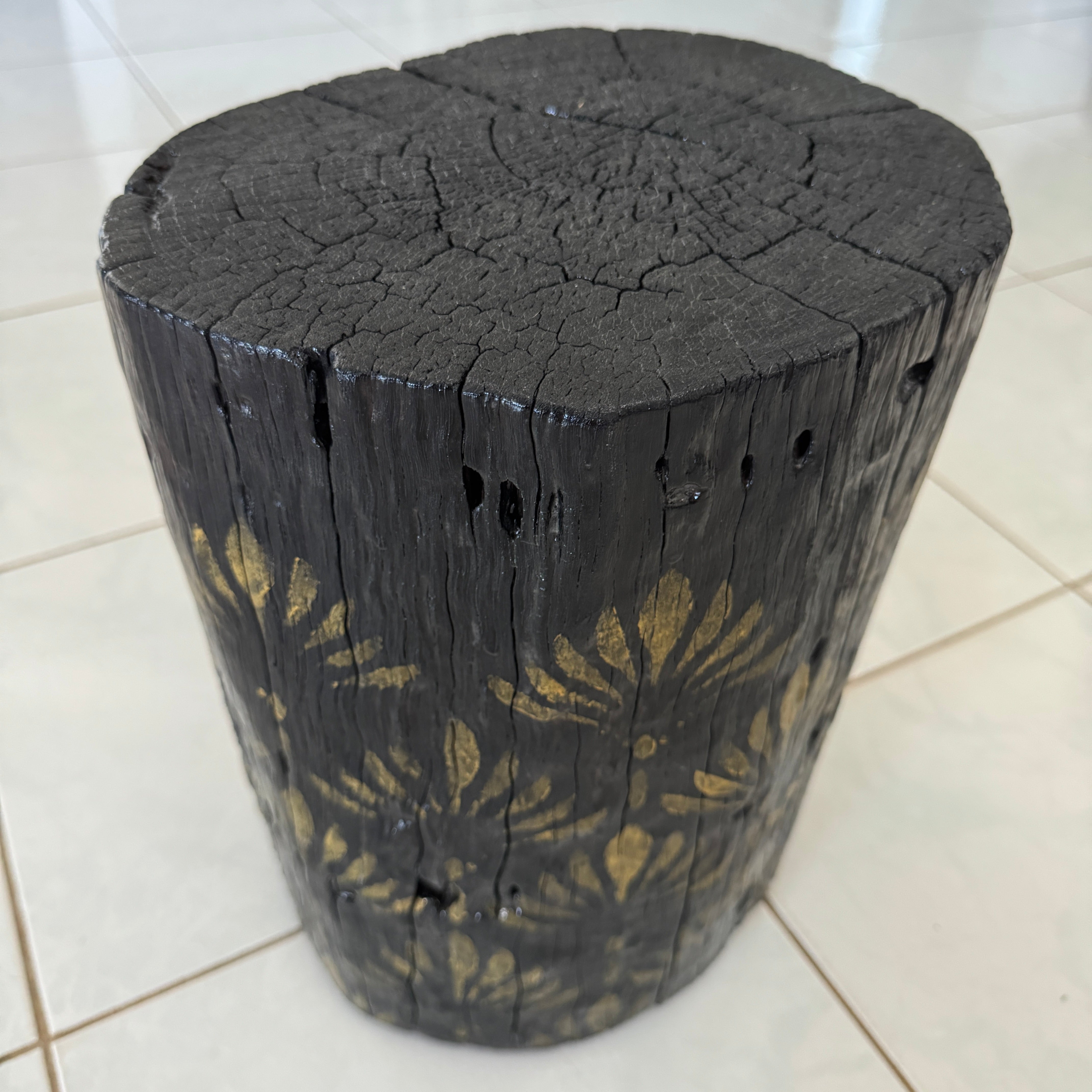 Burnt Timber stump table featuring gold hand-painted artwork