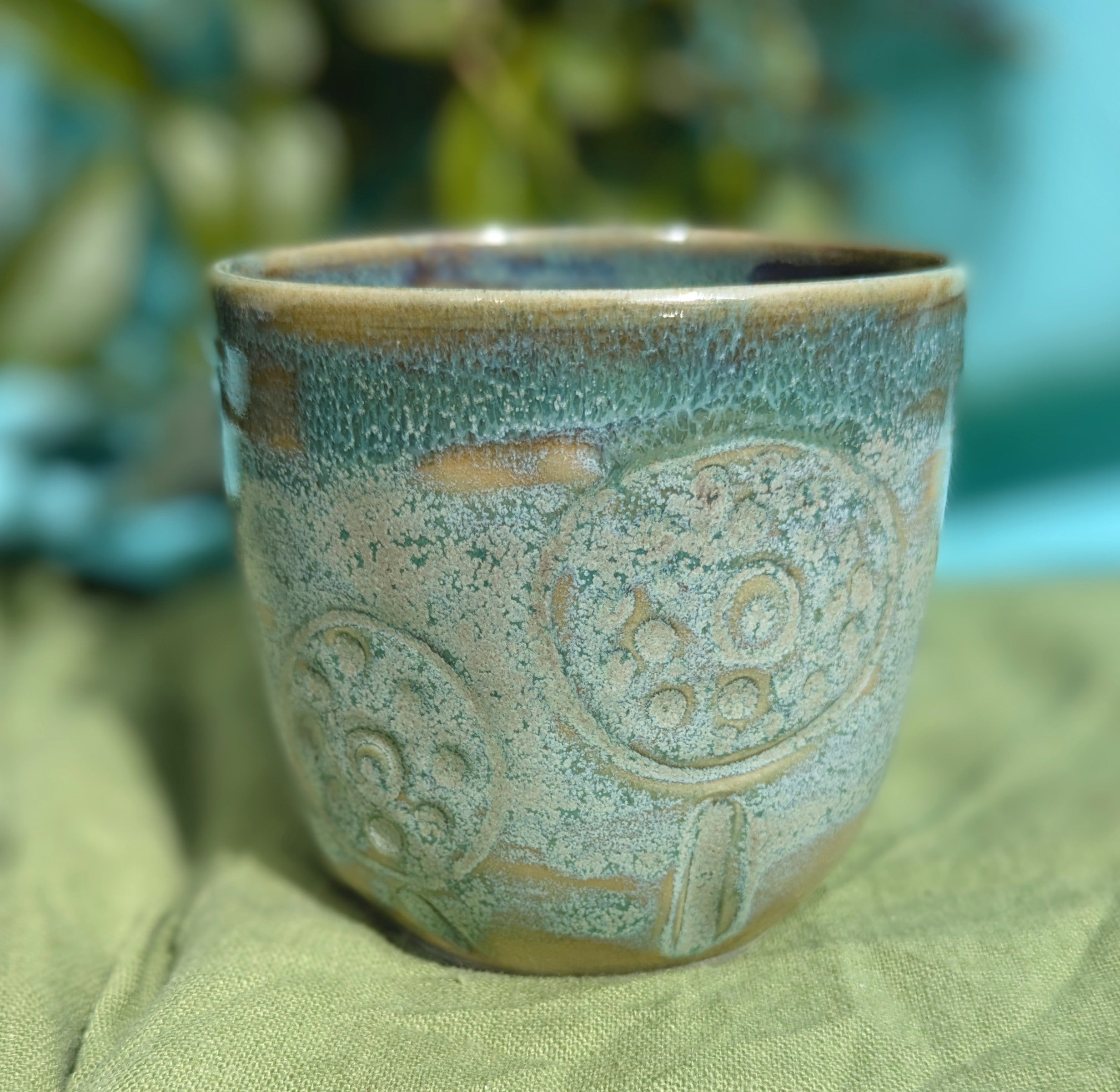 Cup in soft, mottled mossy greens and warm sandy colour