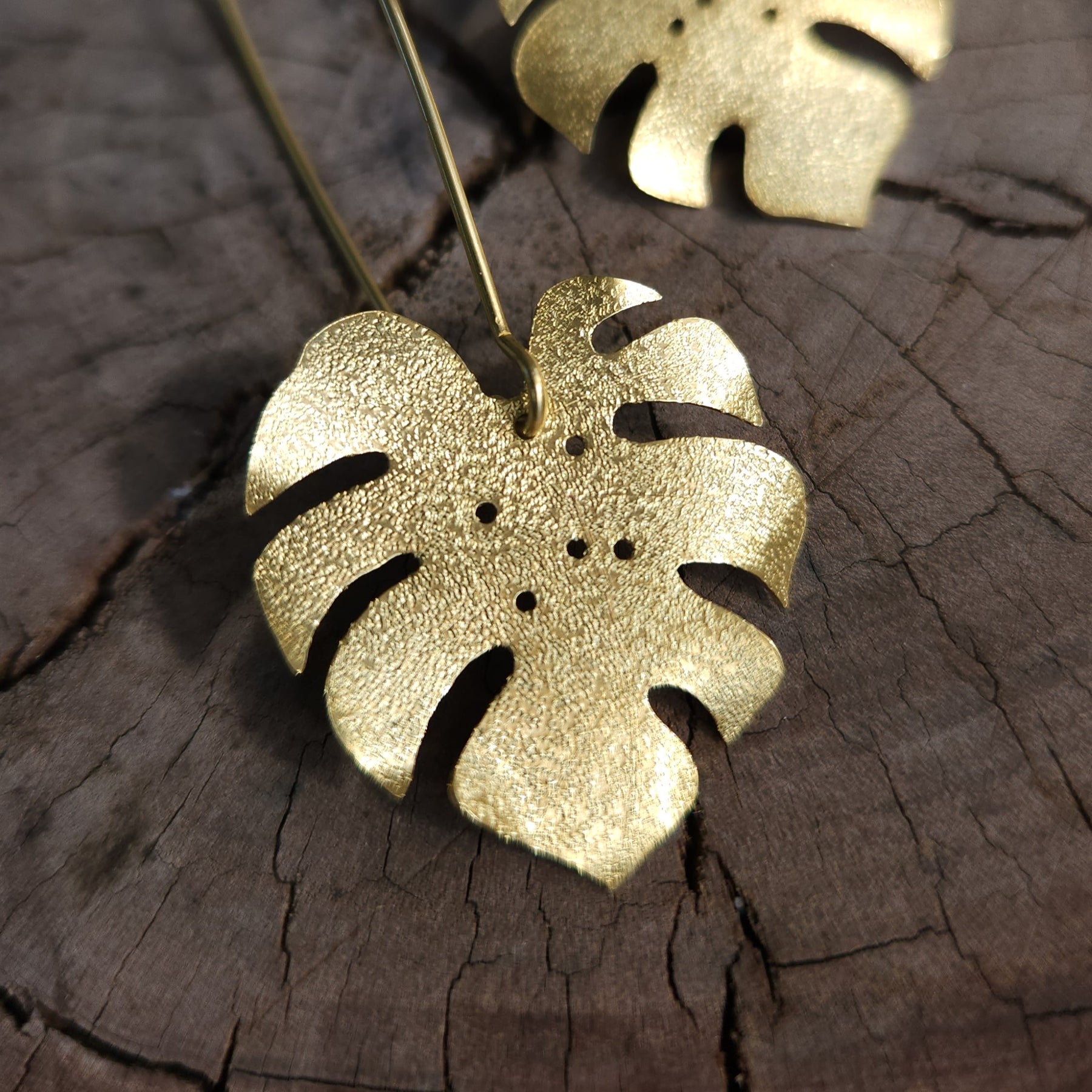 Golden tone monstera earrings