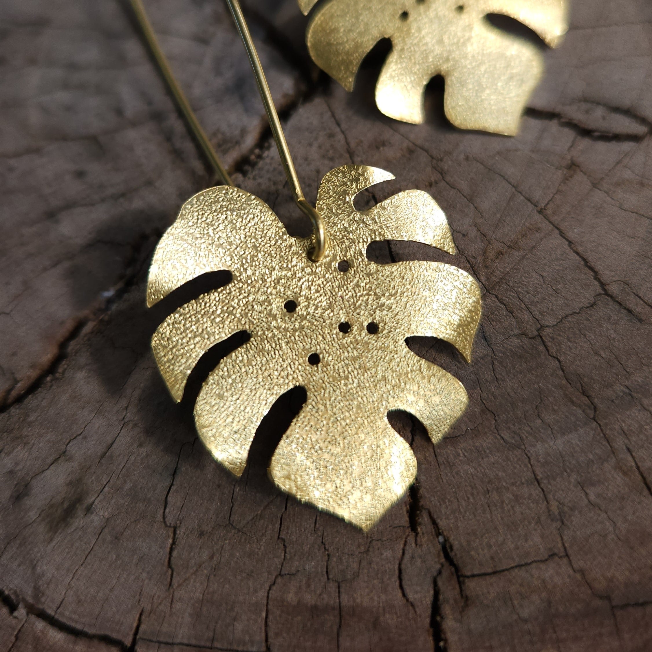 Golden tone monstera earrings