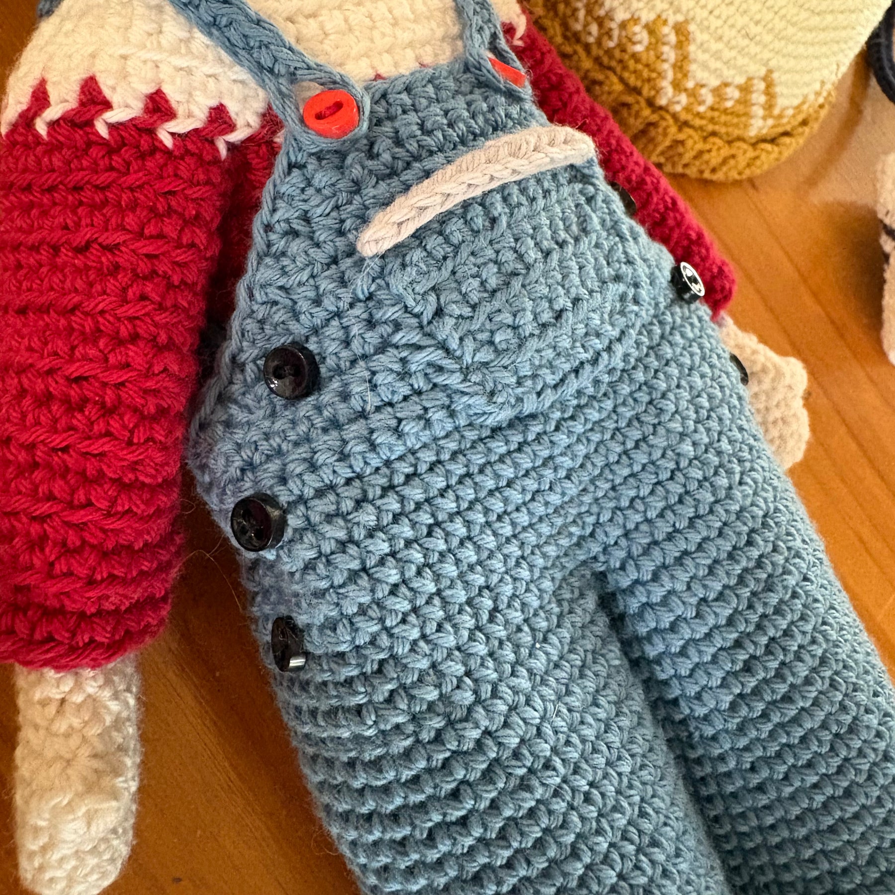 Crochet doll in overalls and beanie.