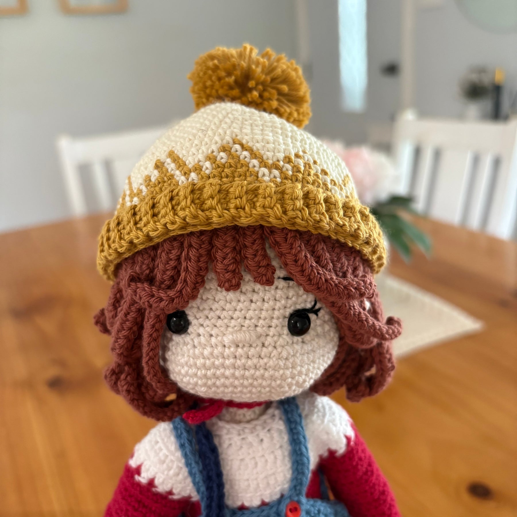 Crochet doll in overalls and beanie.