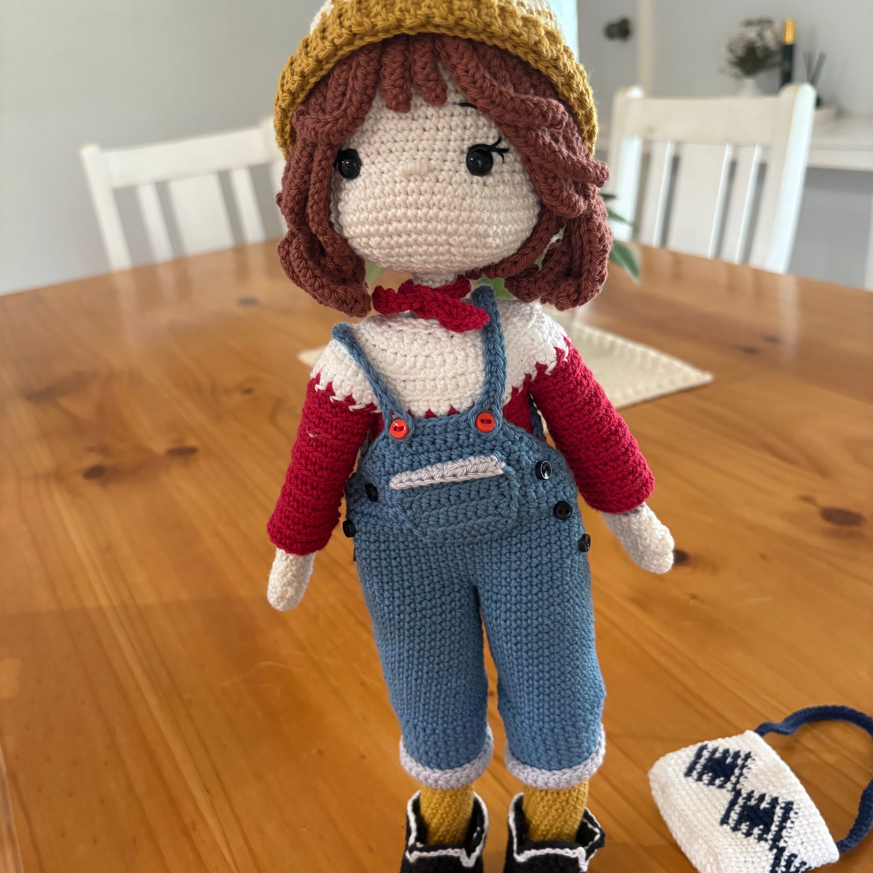 Crochet doll in overalls and beanie.