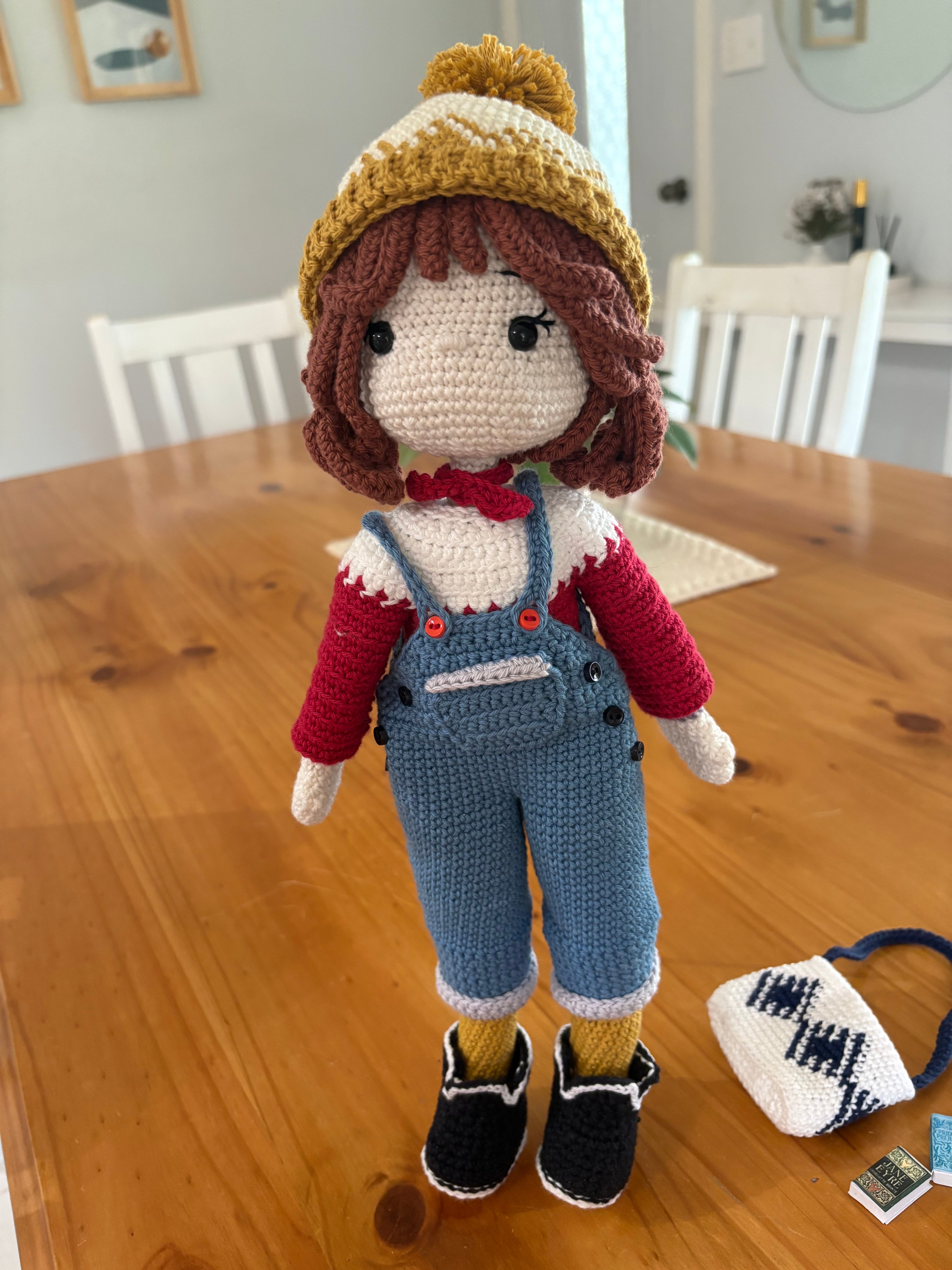 Crochet doll in overalls and beanie.